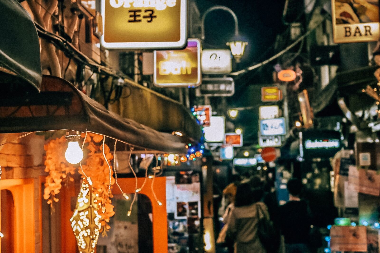 A awning with a light at night  in the streets of Golden Gai