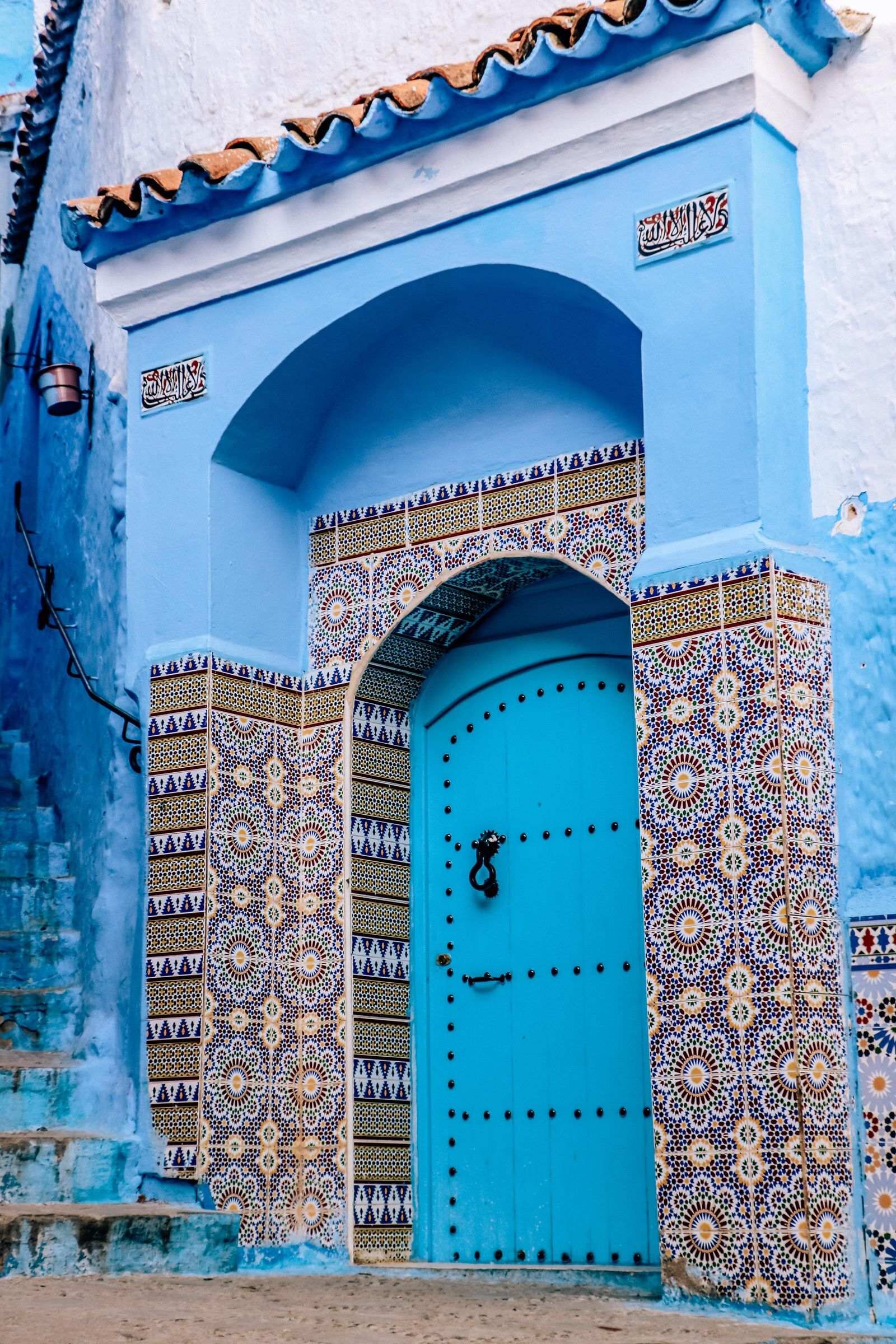 A blue door surrounded by colorful tiles in Chefchaouen
