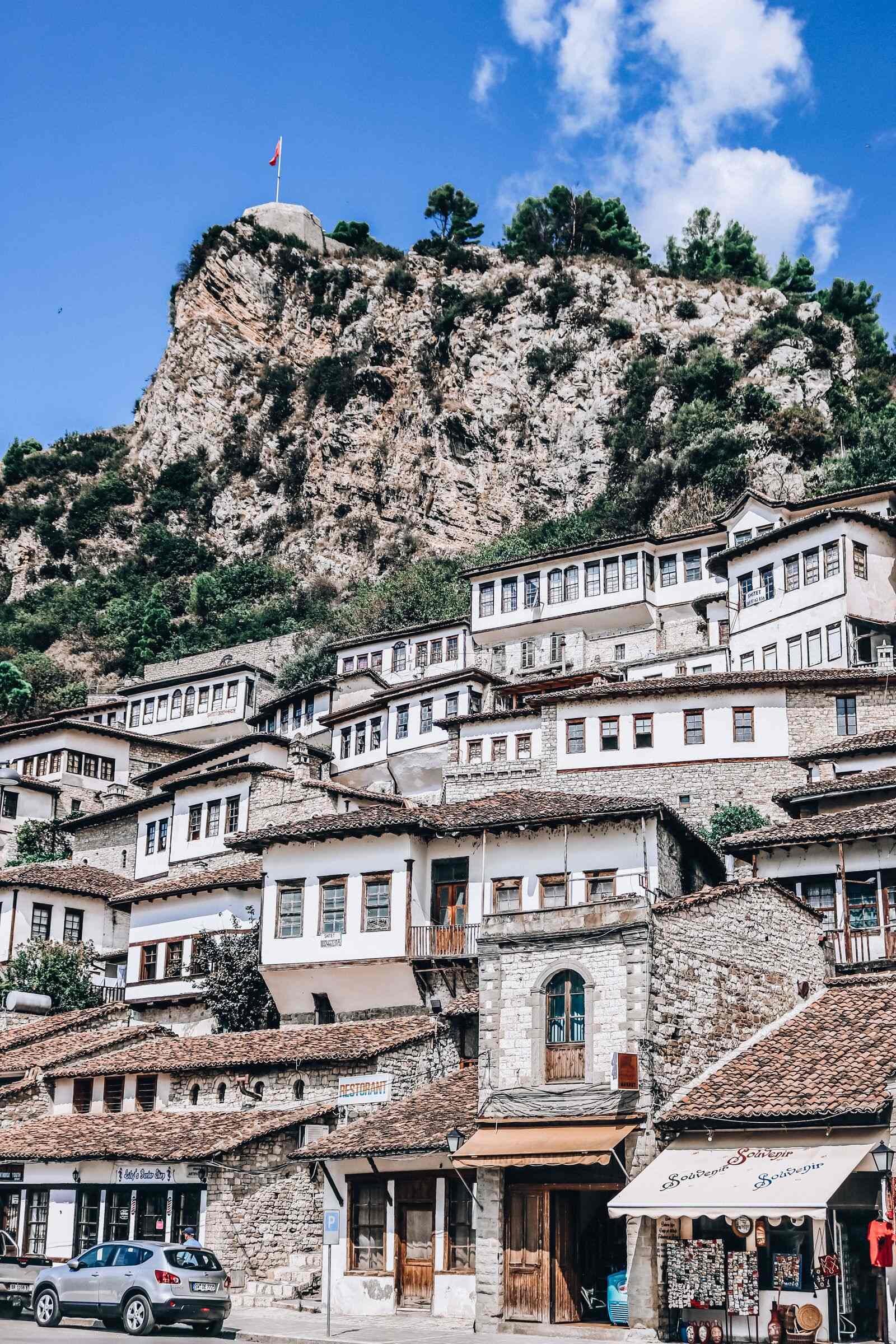 white houses built into the cliffside with a fortress on the top