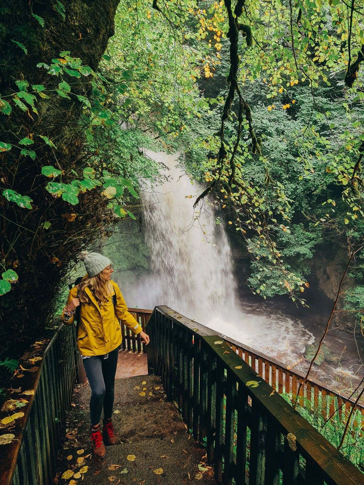 girl walking up stairs in front of a waterfall