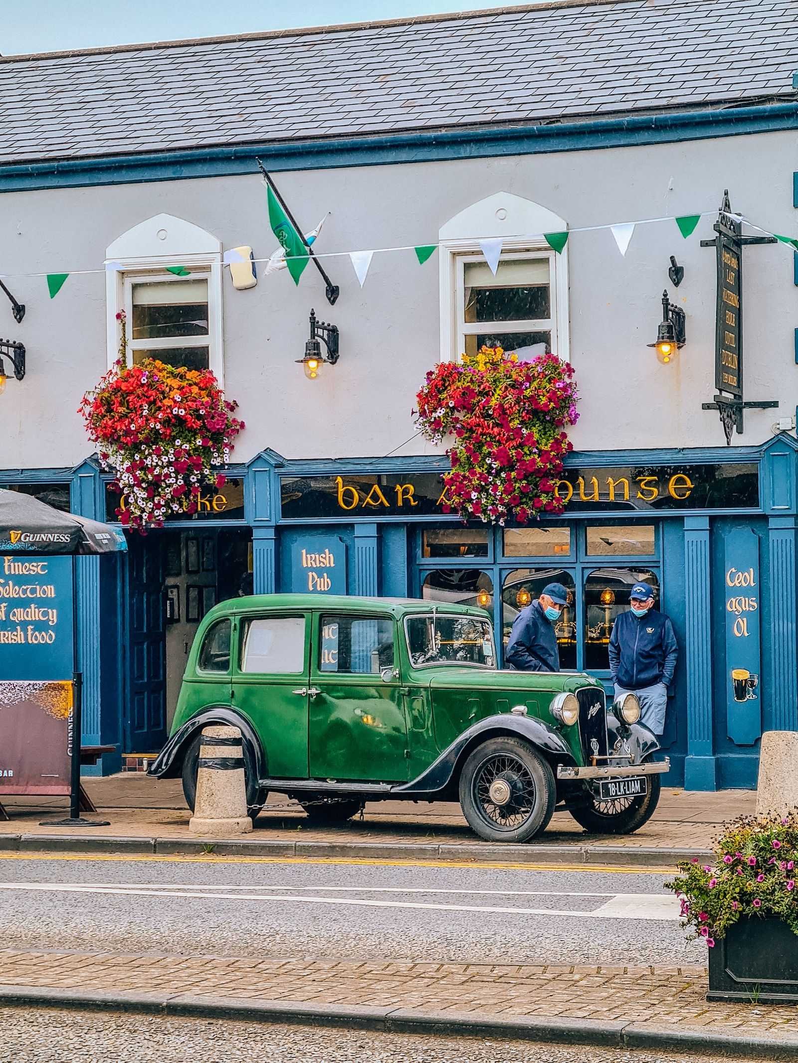  Colourful  shop with a green classic car in front 