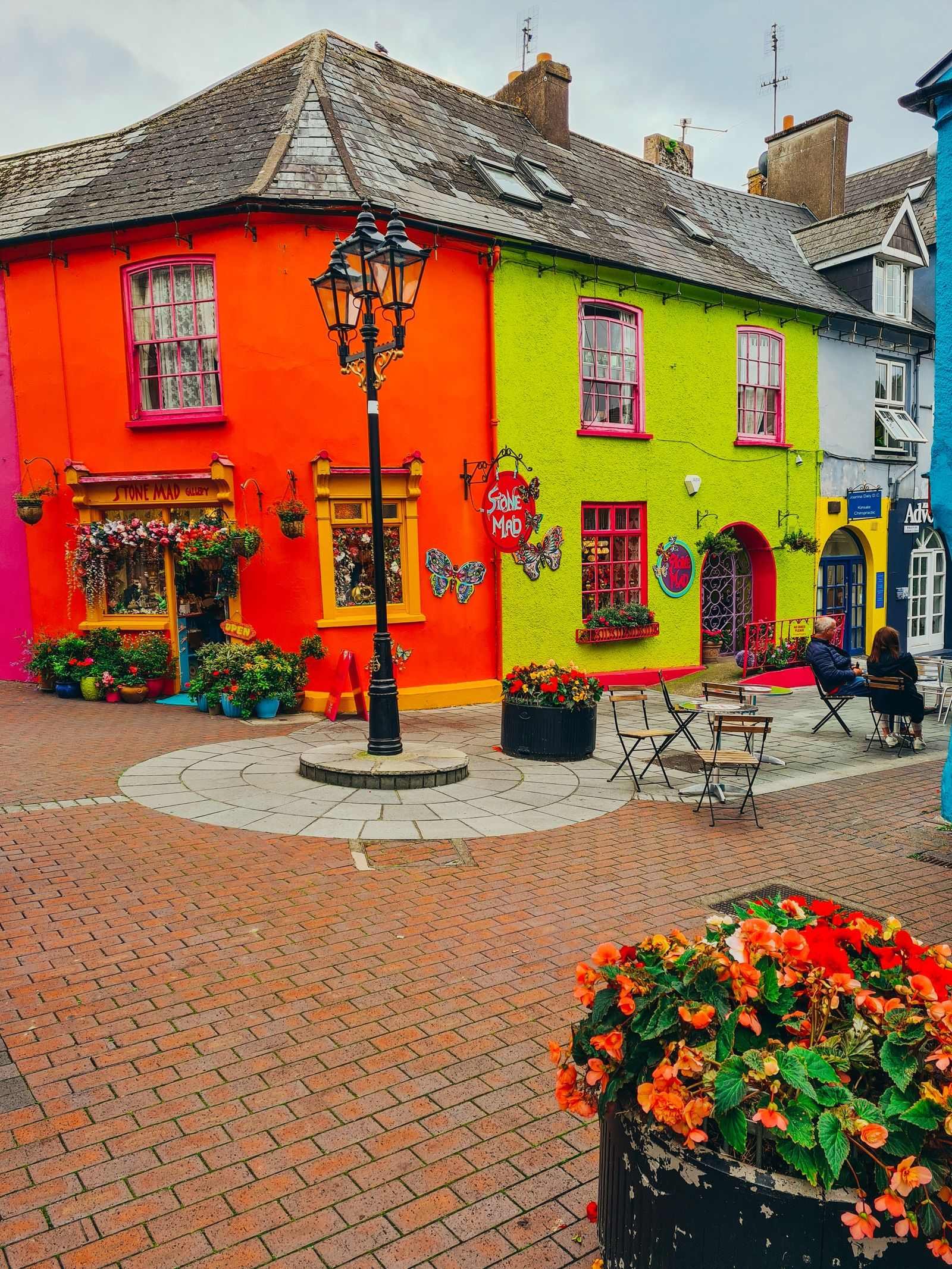  Bright orange and lime green shops with a light post in front 
