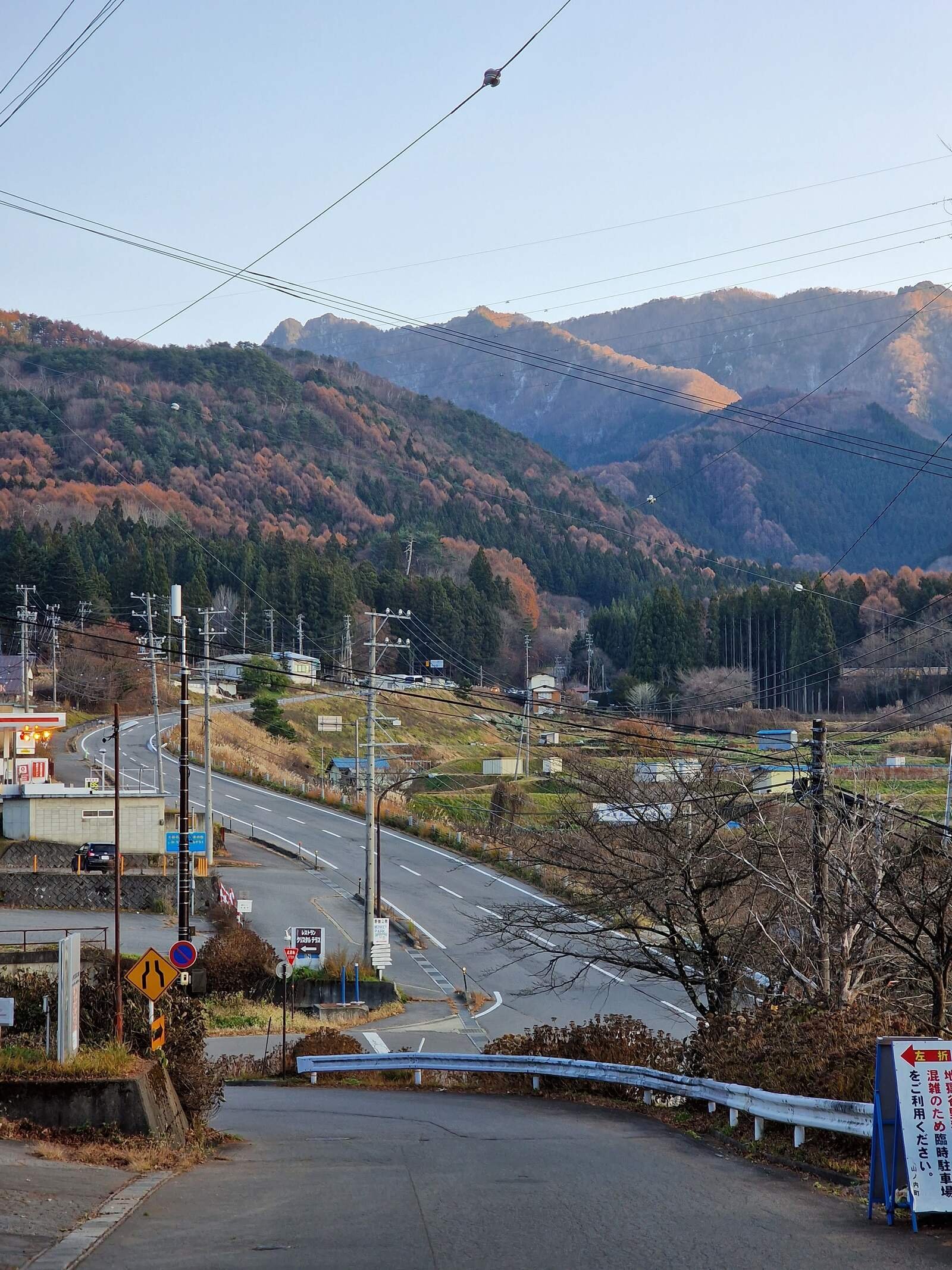 a main road in japan with mountains in the background