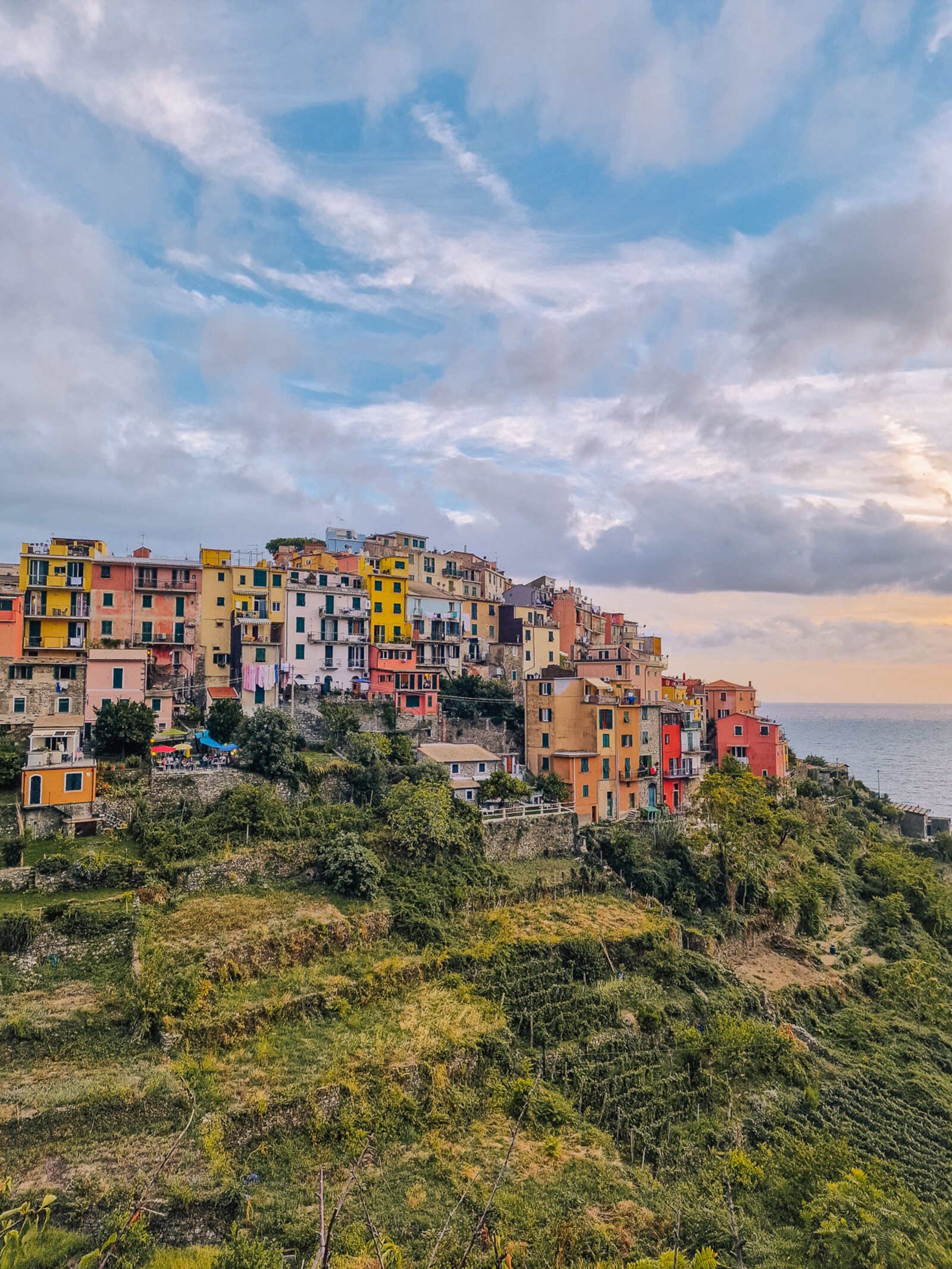 colourful houses on a hill with the sea in the distance