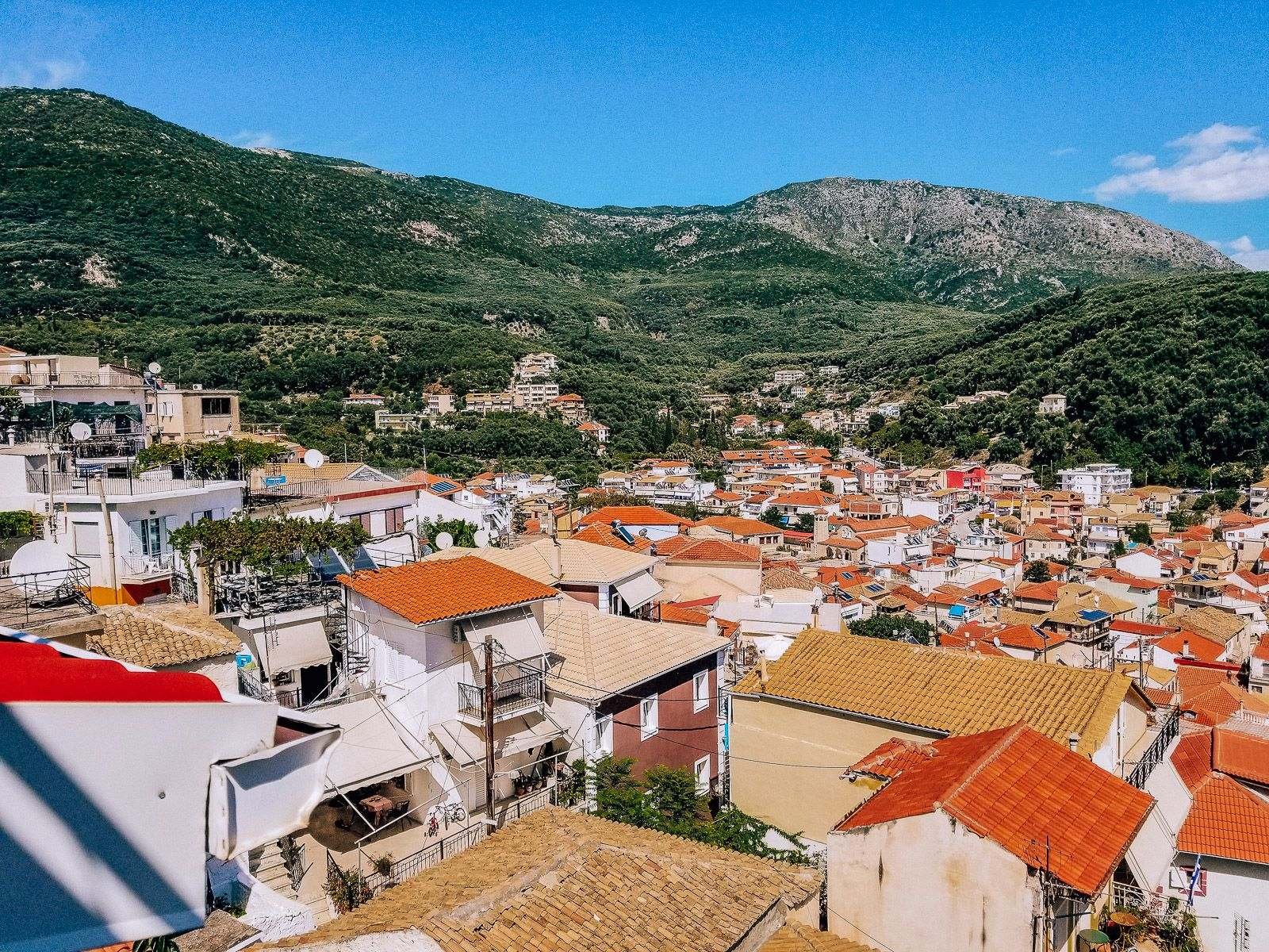 view over orange rooftops of Parga with green hills in the background