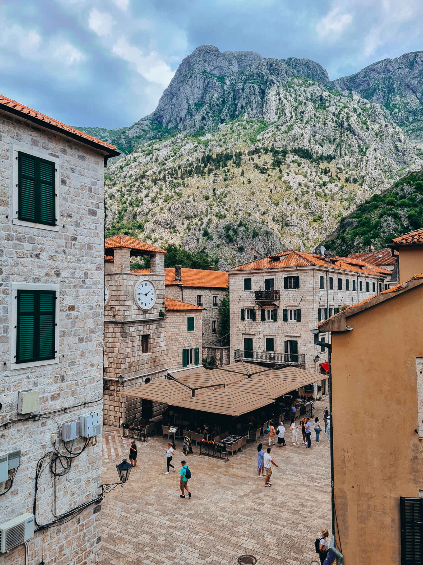 an old town square with cobbled street and mountains behind in Kotor, Montenegro