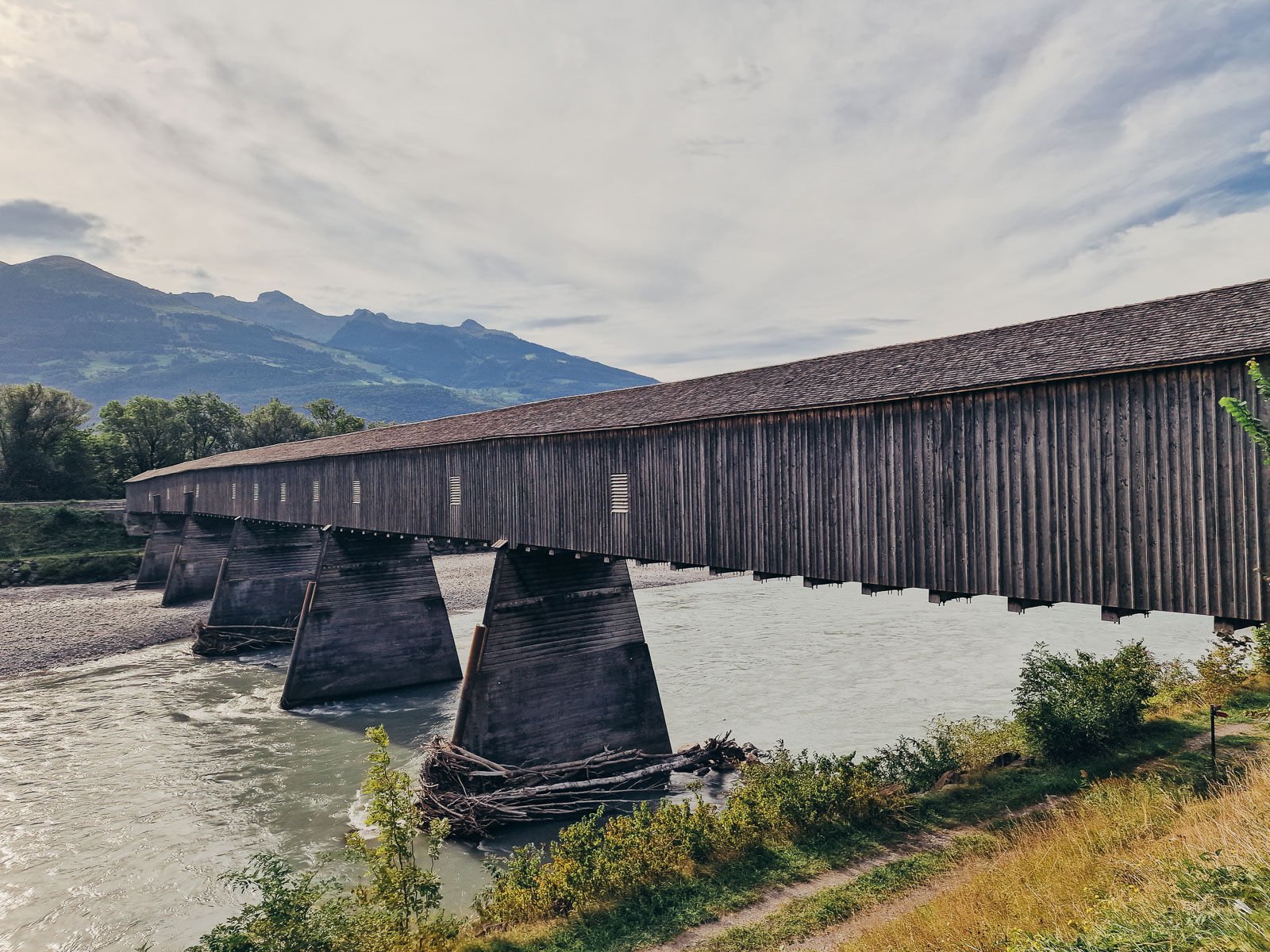 An old wooden covered bridge crossing the river between Liechtenstein and Switzerland