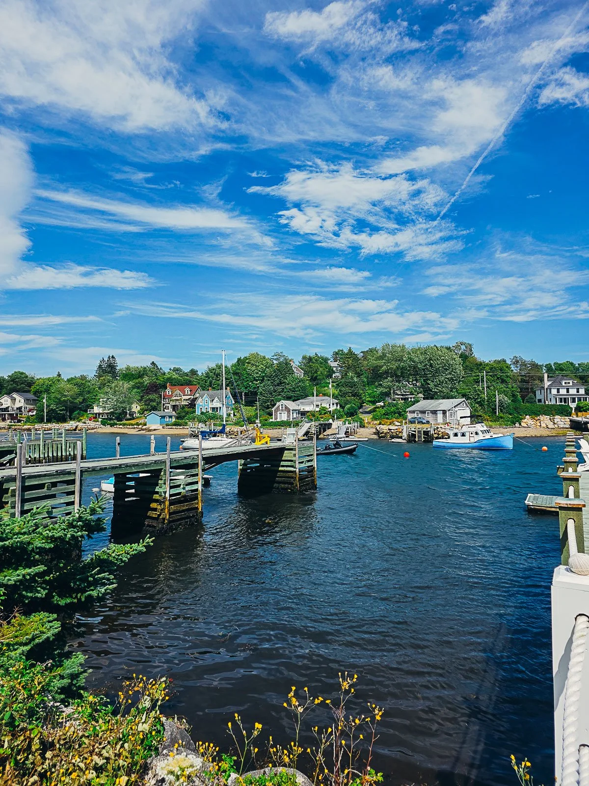 a small private pier stretching out into a calm harbour with some small boats anchored on a sunny day in Chester on the South Shore Lighthouse Route