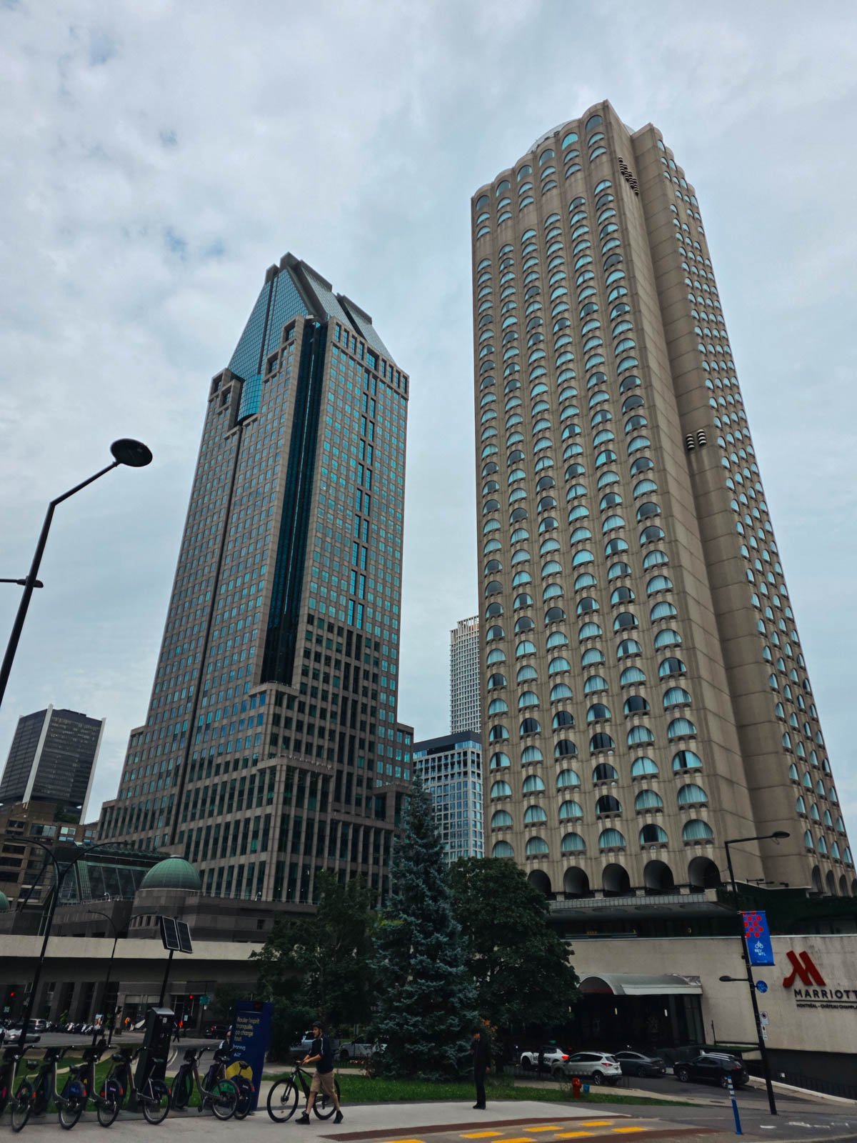 Two skyscraper buildings of grey stone and lots of windows in downtown Montreal