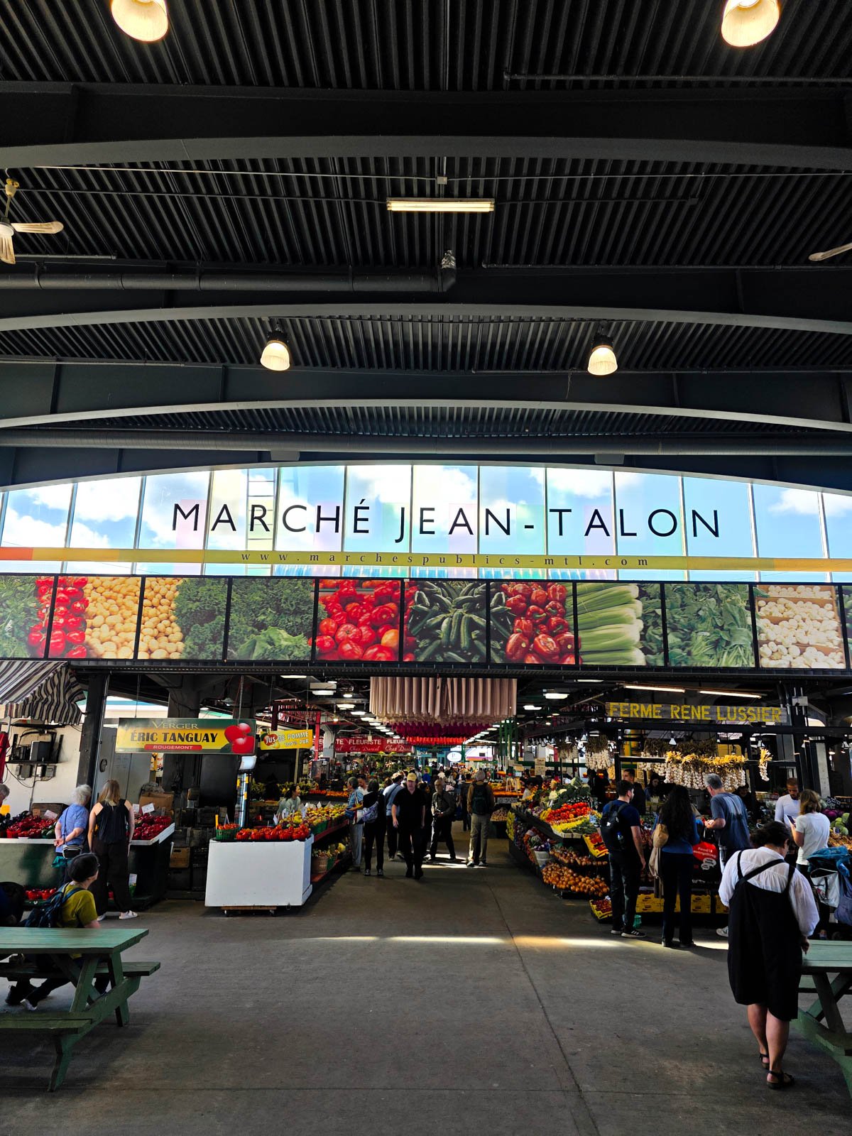 An indoor market building with a sign over the entrance that reads "Marche Jean-Talon"