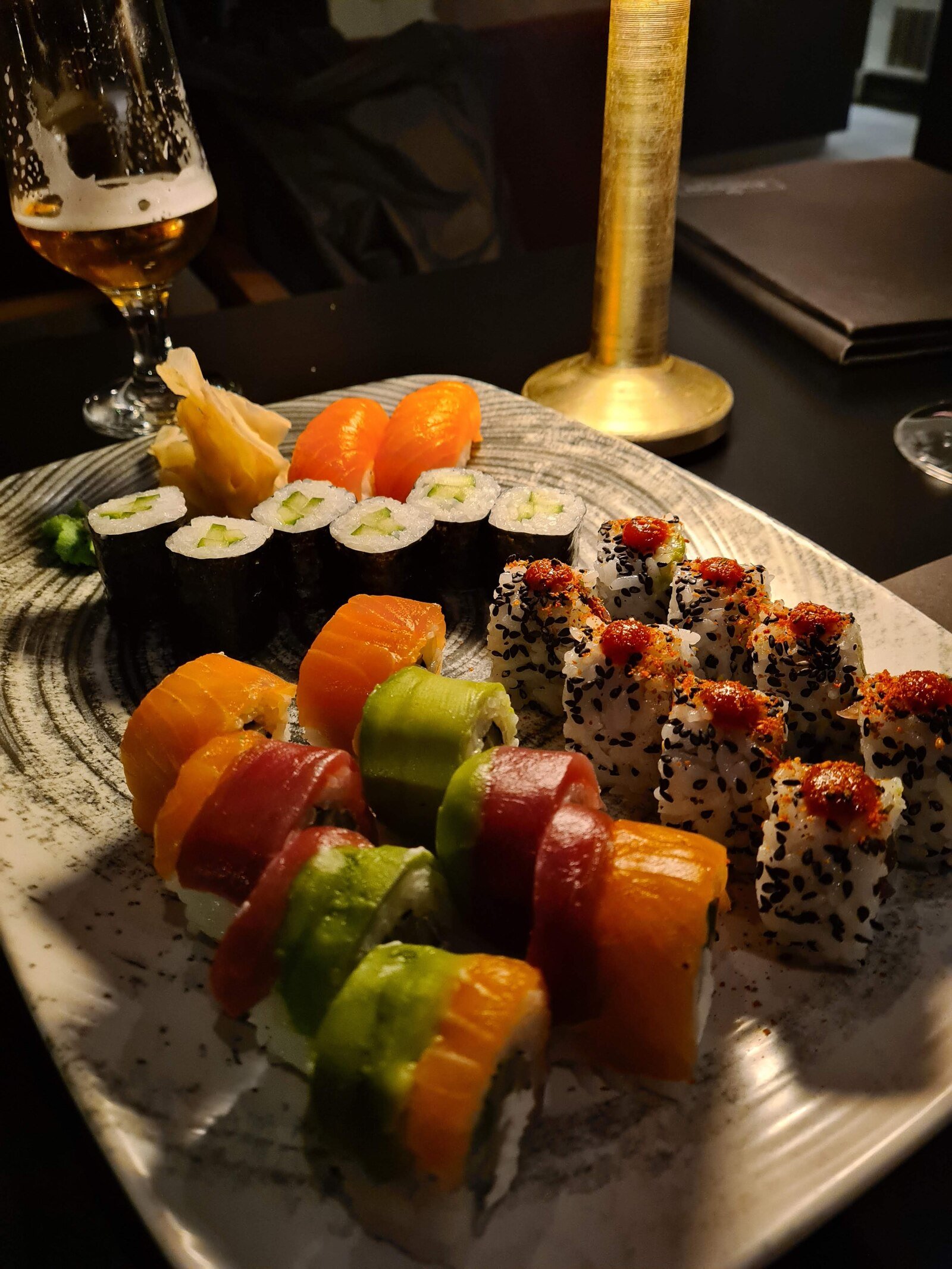 A rectangle plate with many colourful pieces of sushi
