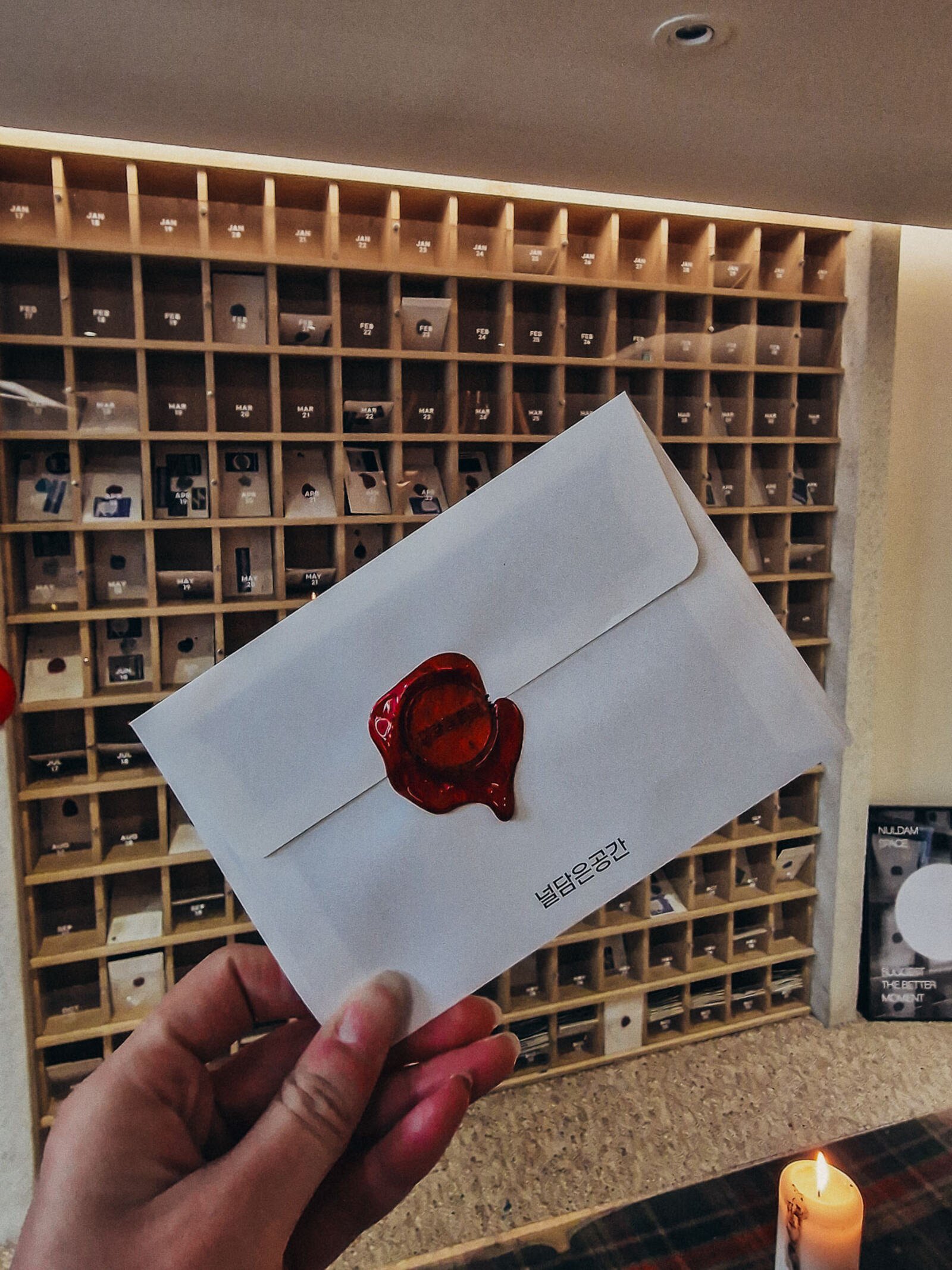 a white envelope with a red wax seal on it, being held up to the camera