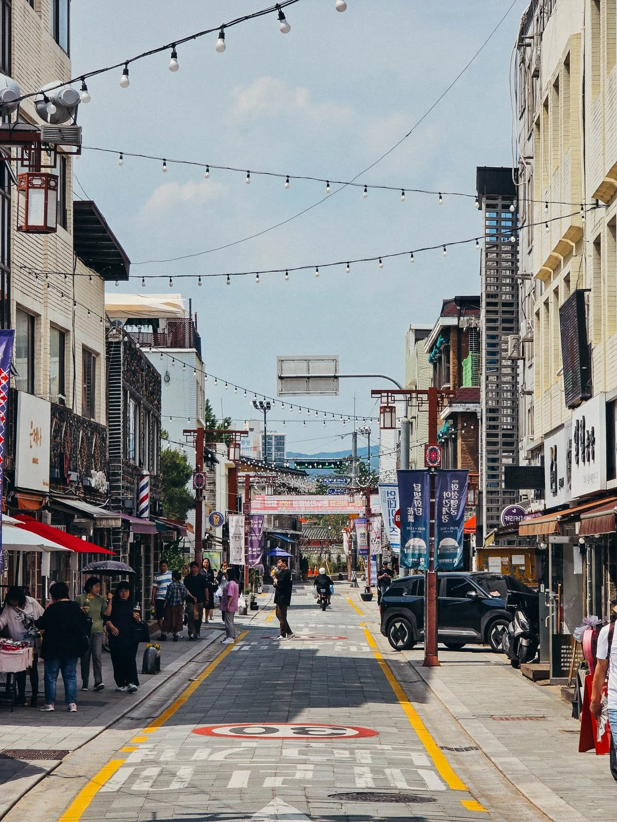 A busy retail street filled with many different shops and cafes
