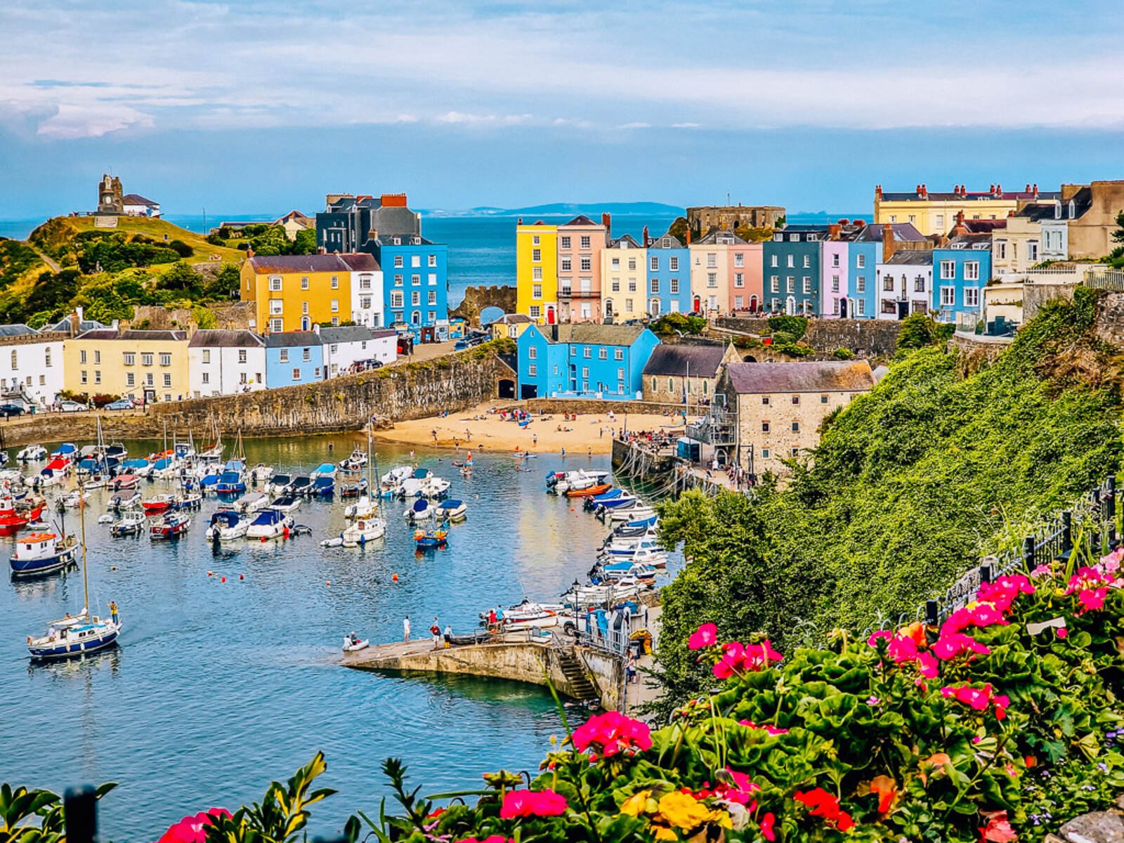 Looking across a harbour full of boats and lined with colourful houses at Tenby in Wales