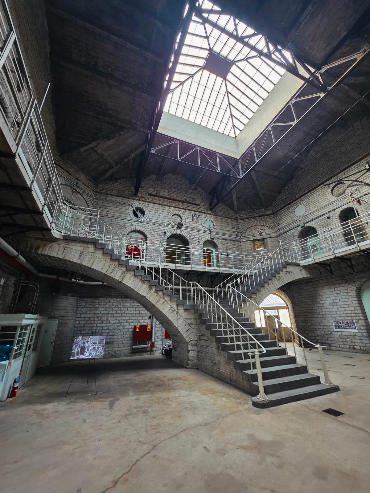 A large split staircase in a tall stone block building with a large skylight