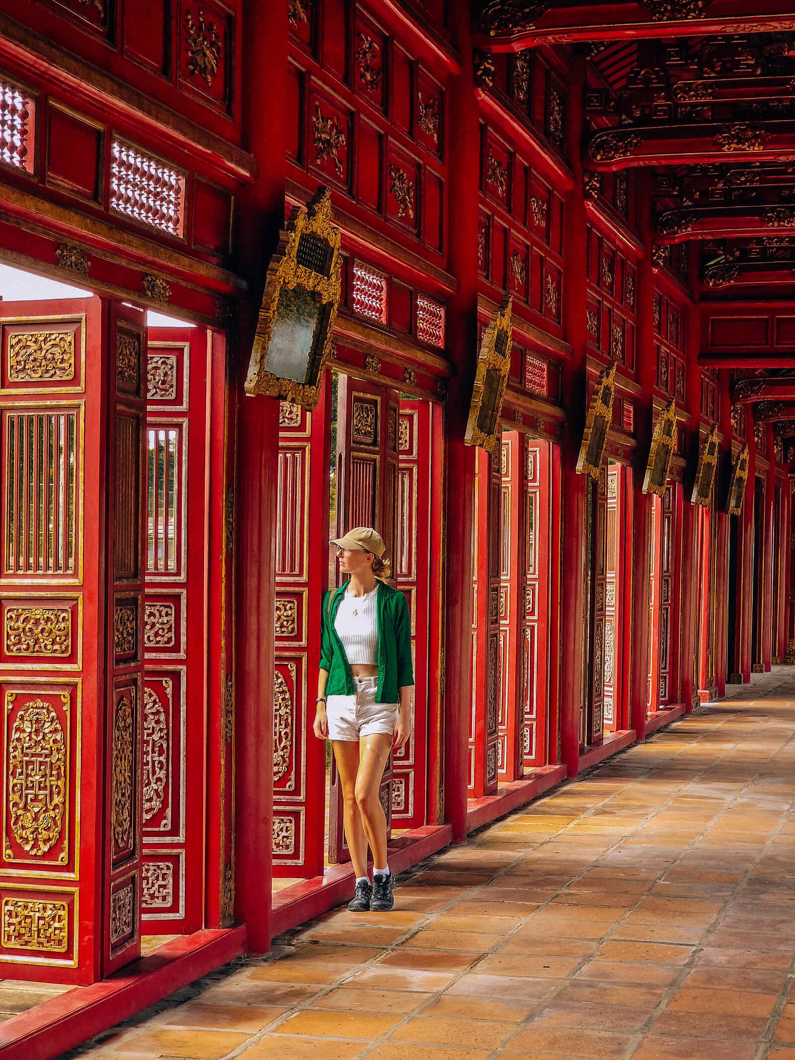 a line of red doorways with ancient carving detail and Helena standing in front