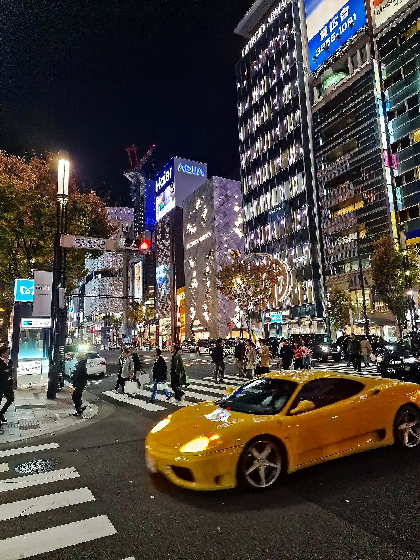a yellow sports car on the street at night in ginza tokyo