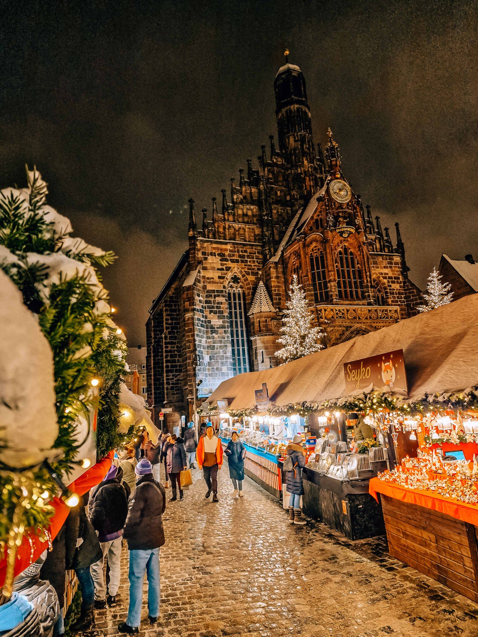 looking through colourful market stalls to see the gothic church in nuremberg