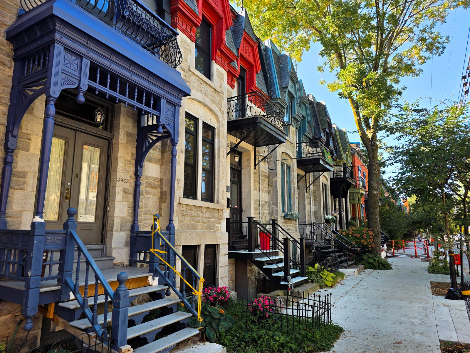 Beautiful Victorian Gothic style houses in Montreal, made of stone with colourful porches in purple, red and blue
