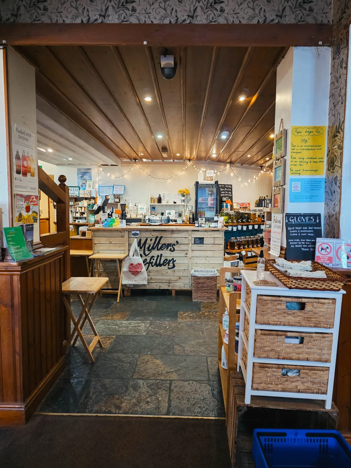 Inside a refill store with wooden counters and flagstone floors with lots of products on display