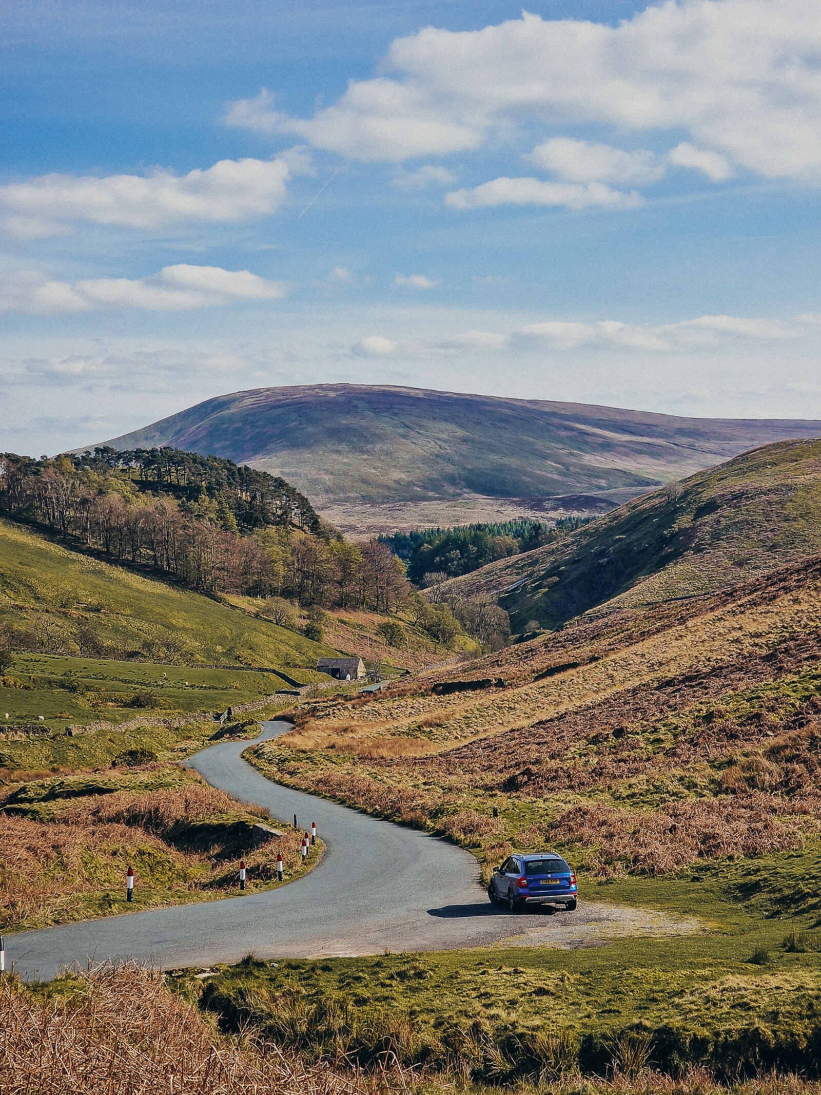 forest of bowland road trip through the countryside with a winding road and a car in the distance