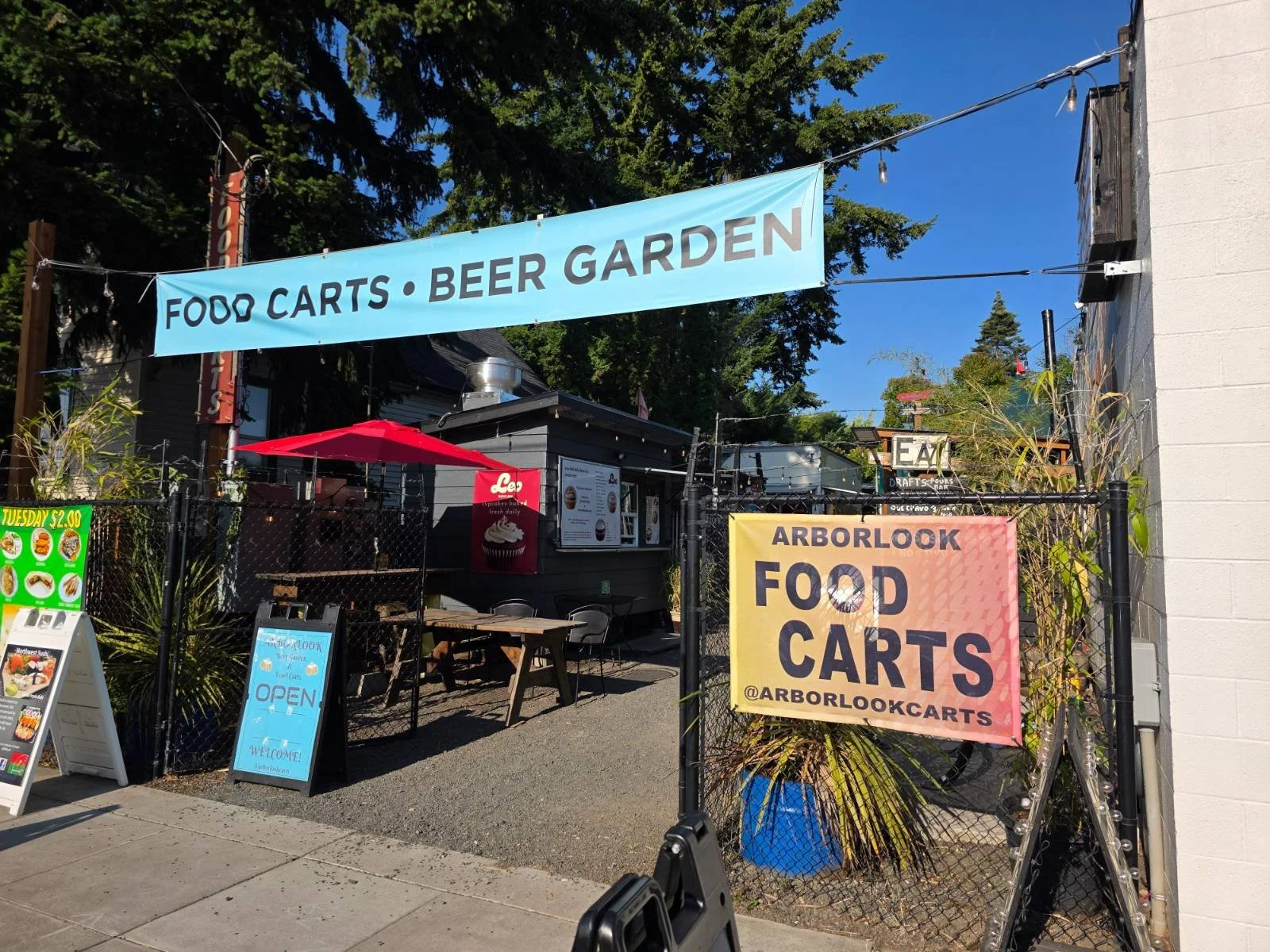 The entrance to a food cart pod with a sign above the gate that reads "food carts - beer garden"