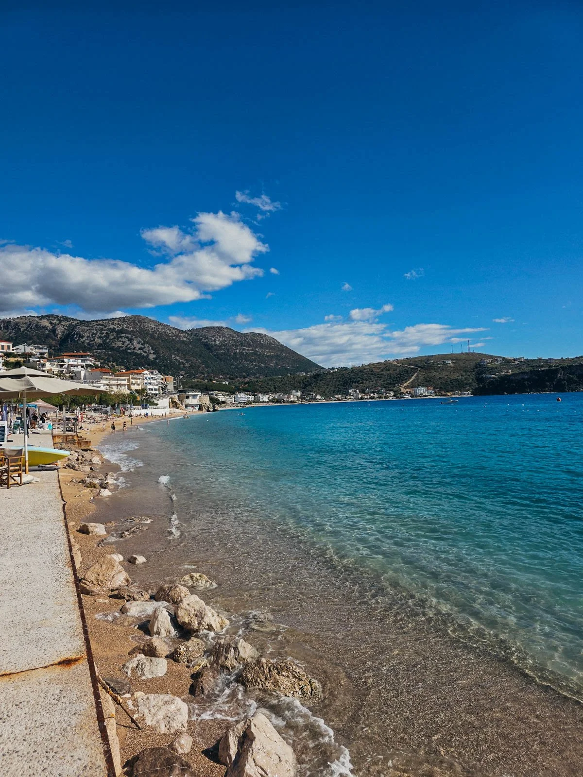 A beach along a seaside town with clear blue water