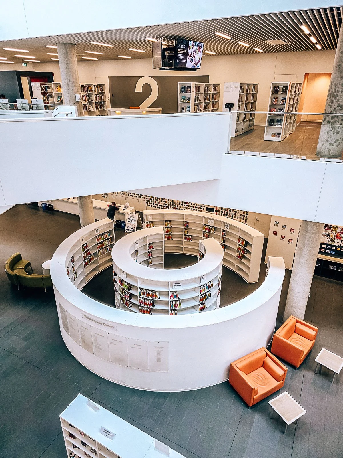 A large library with white circle bookcase at its centre