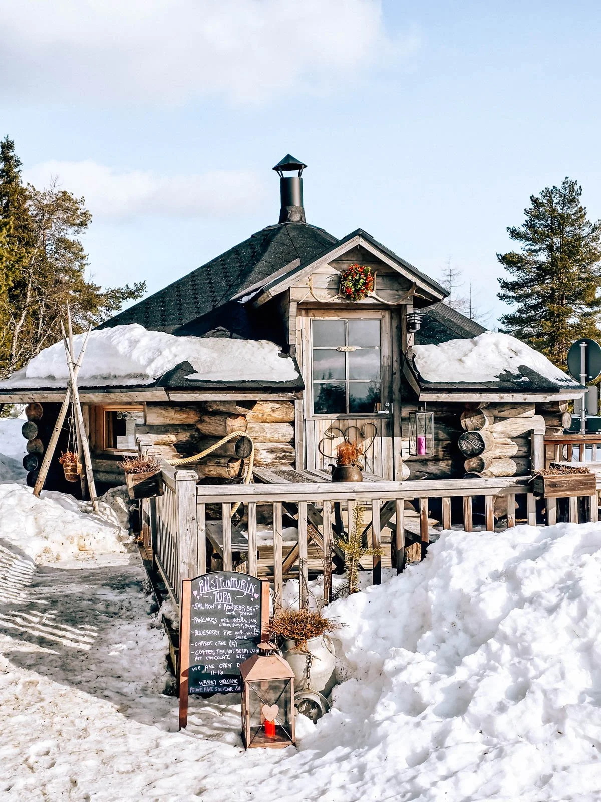 A small log cabin café surrounded by snow