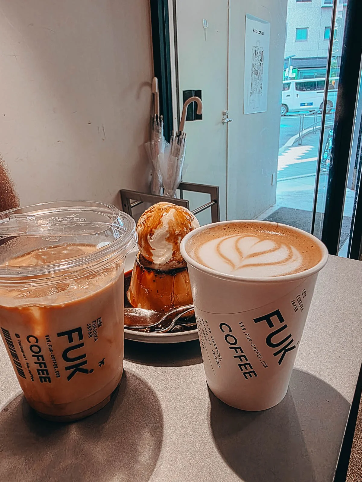 Two coffees and a ice cream desert on a table at a café