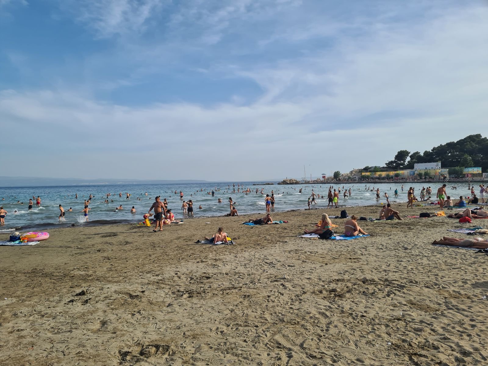 sandy beach and blue sky with people enjoying the sun