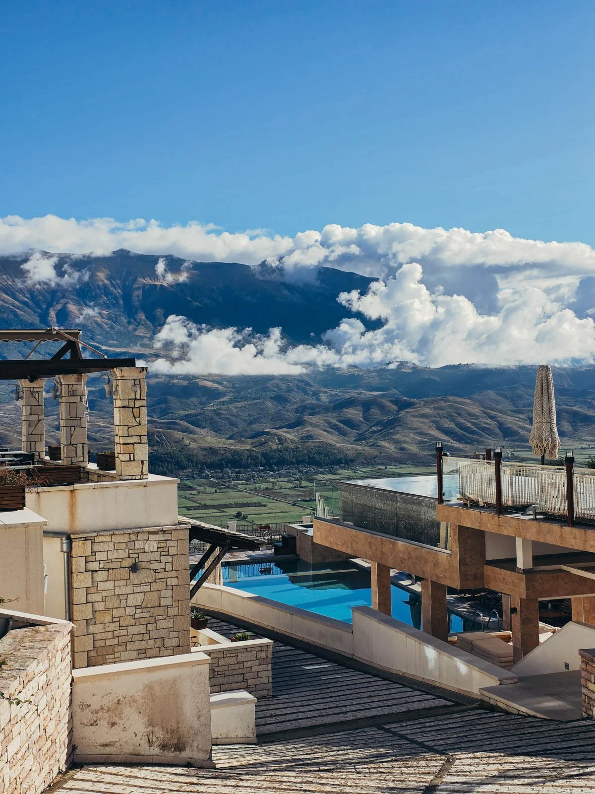 A hotel with a pool with a view of a large mountain range in the distance