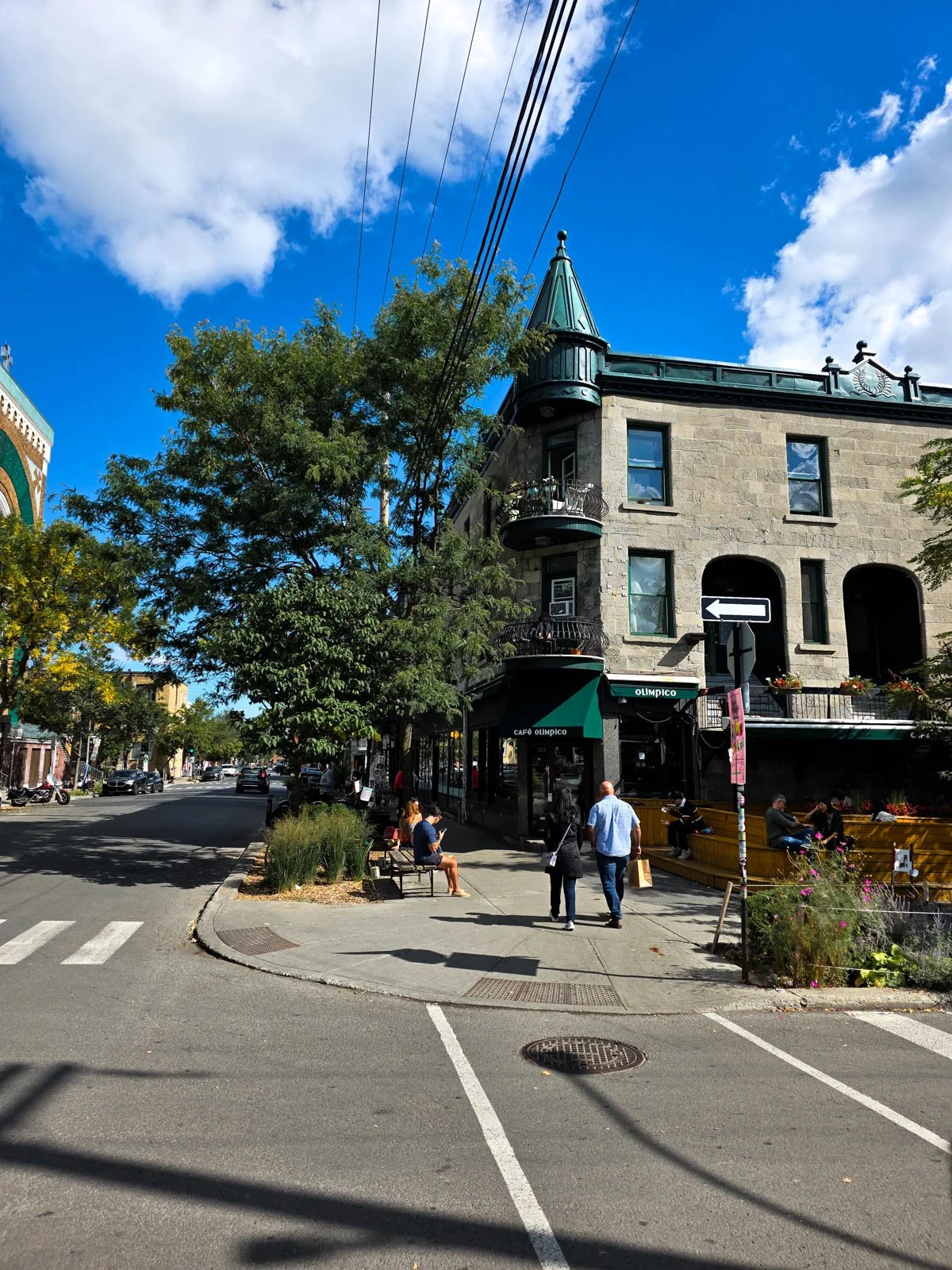 A street corner with a coffee shop with a turret on the corner in a pretty neighbourhood of Montreal