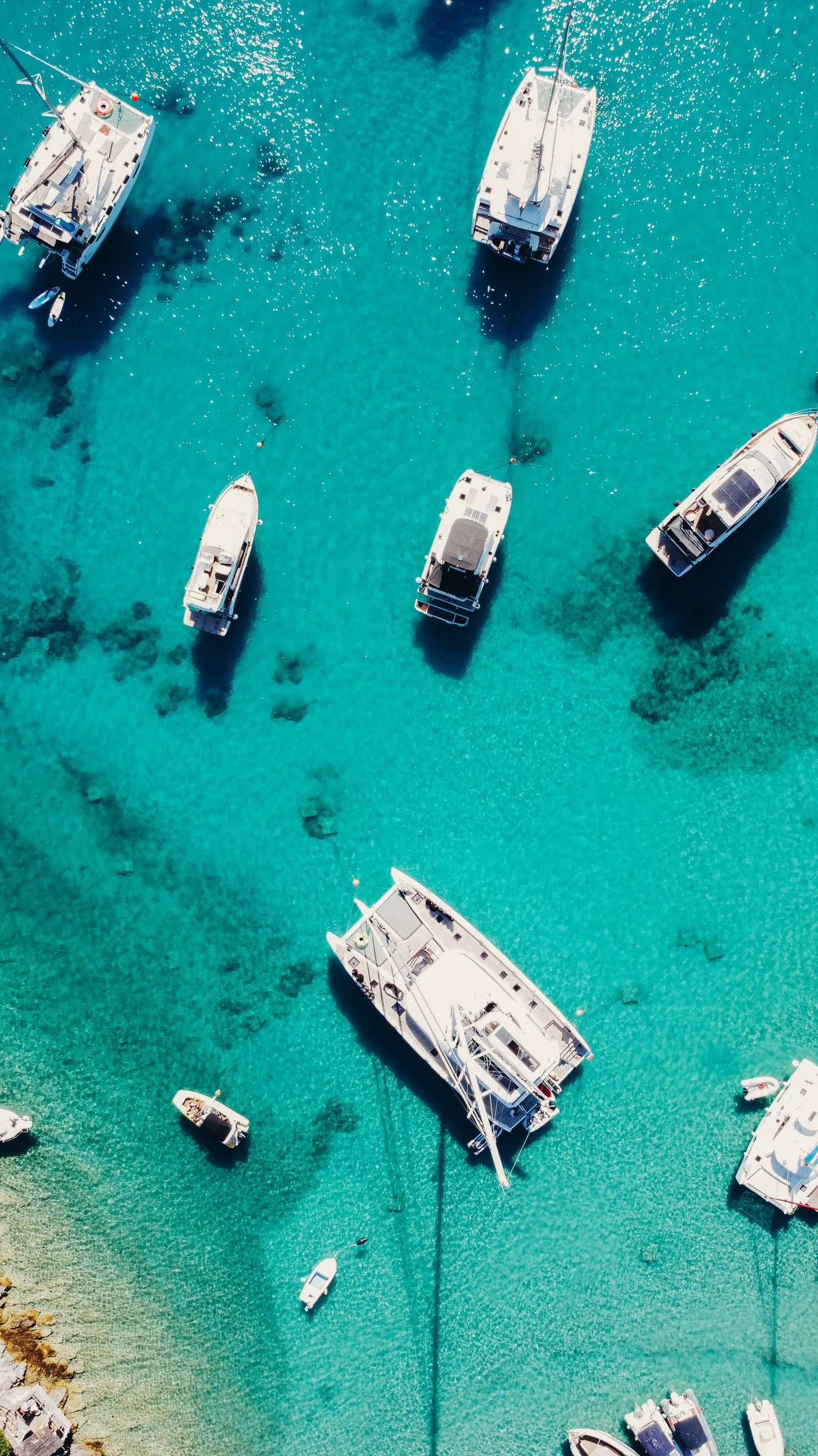 top down view of sailing boats in the turquoise water