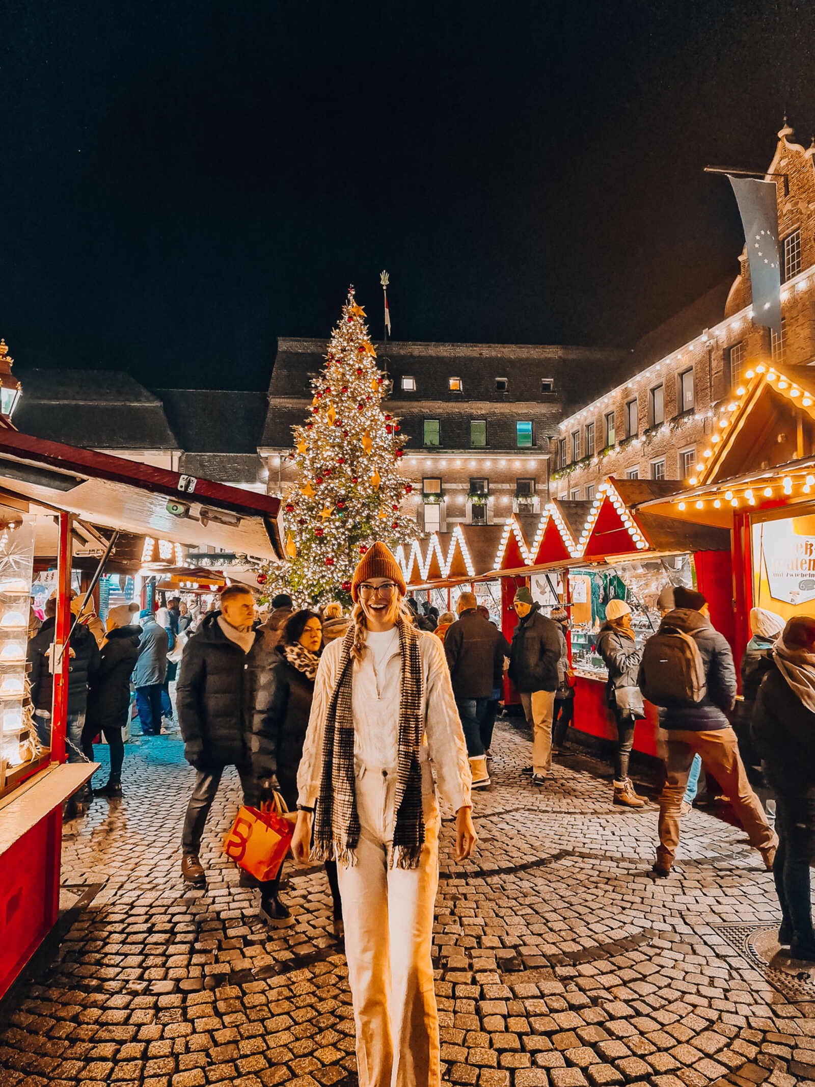 A girl in white standing at the Christmas market