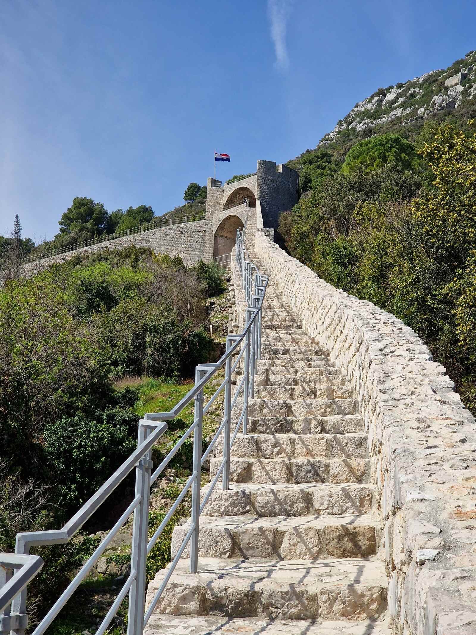 a stone stairway along a long stone wall in Croatia