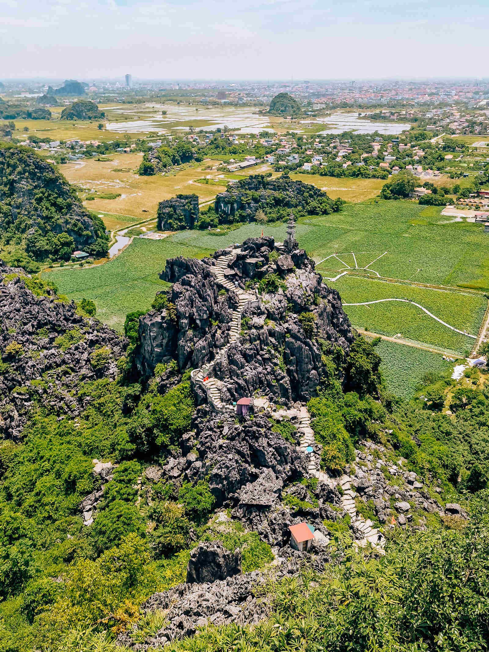aerial view of a rock mountain surrounded by green fields