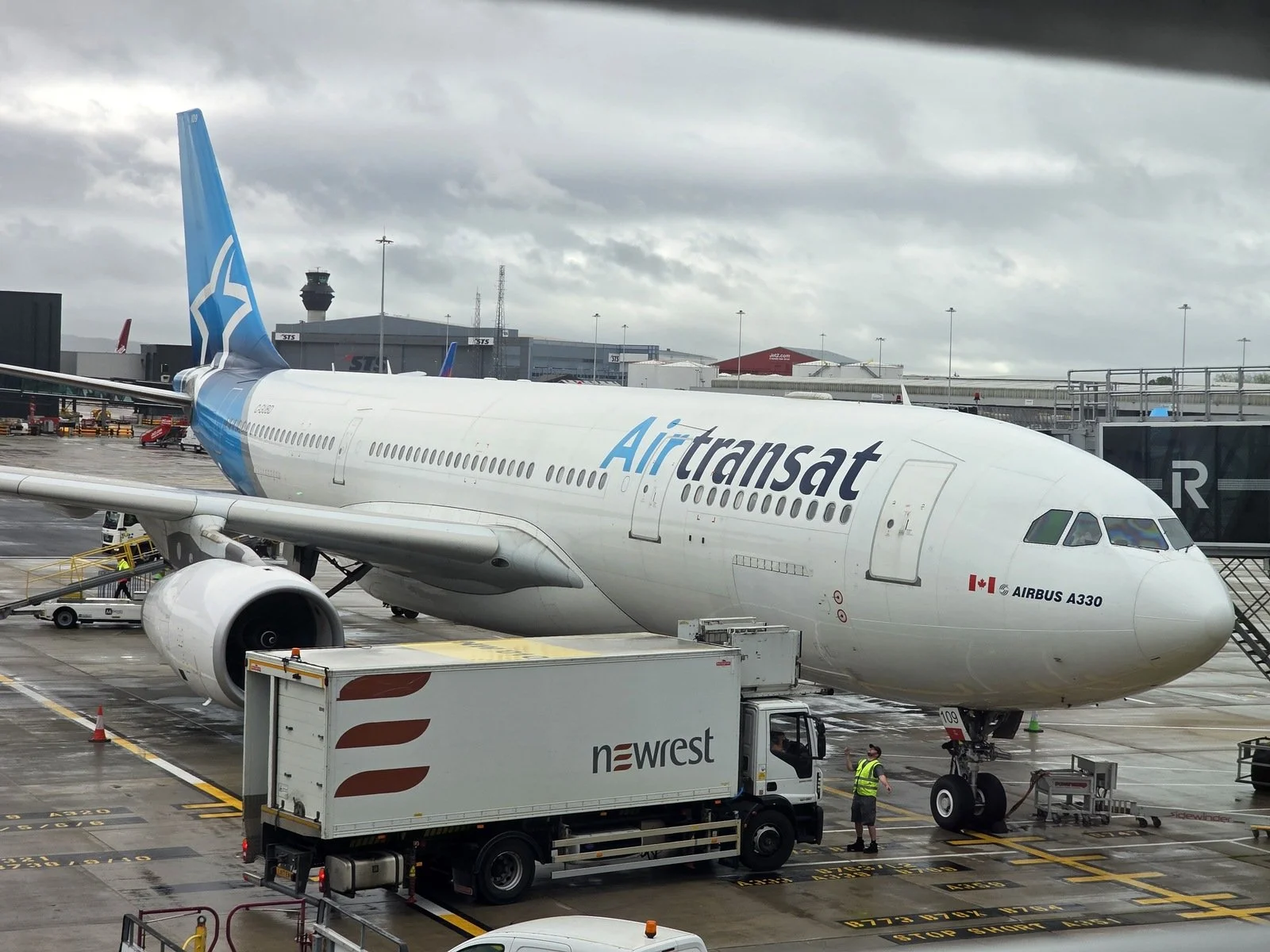 An Airbus A330 airplane parked at the airport with Air Transat branding on the side