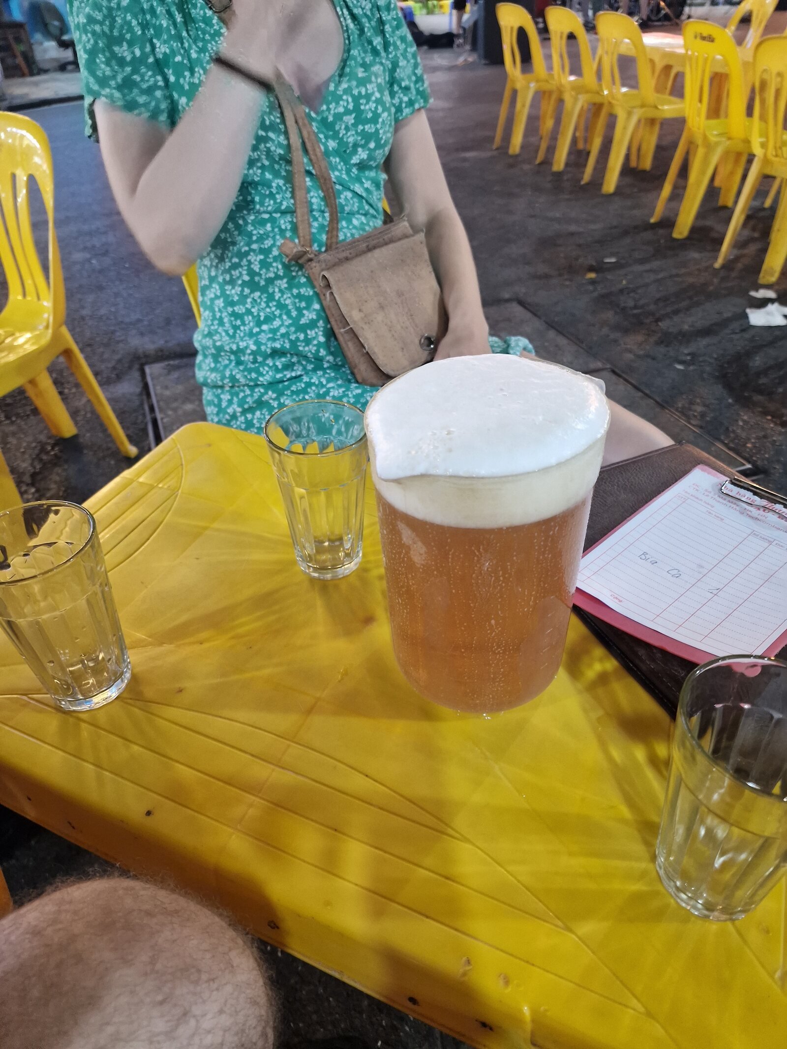 a large jug of beer on a tiny yellow plastic table