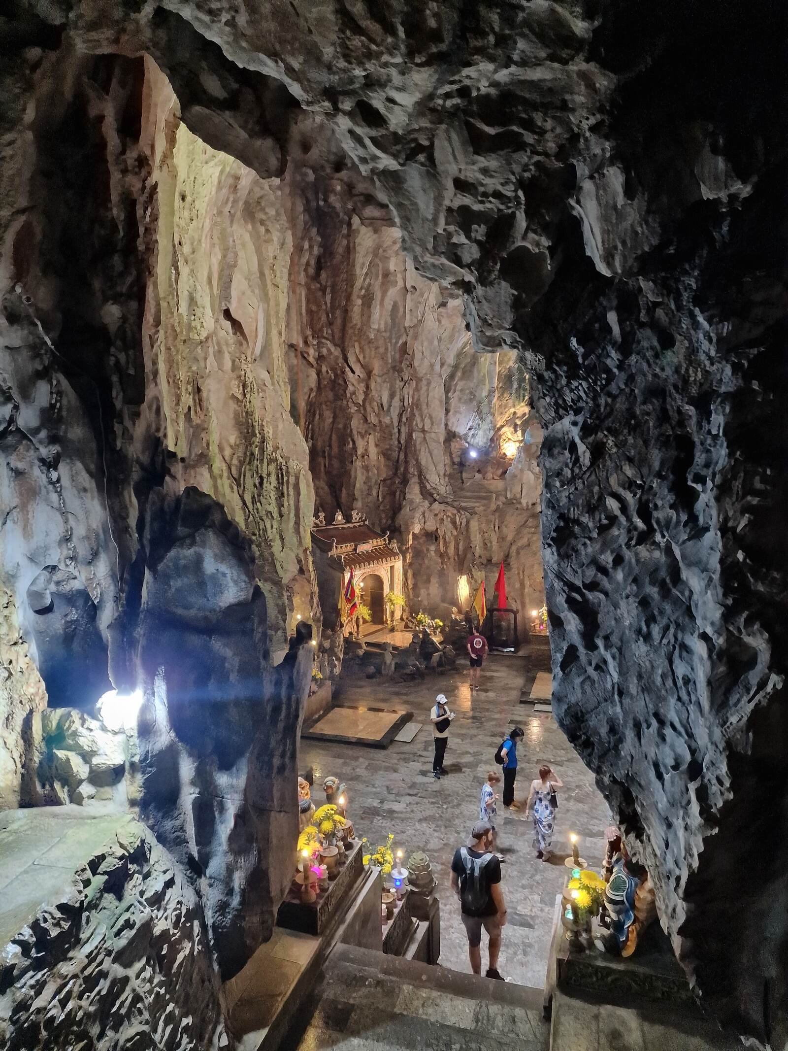 a huge cave with steps down to a pagoda inside in Marble Mountains on a Vietnam itinerary