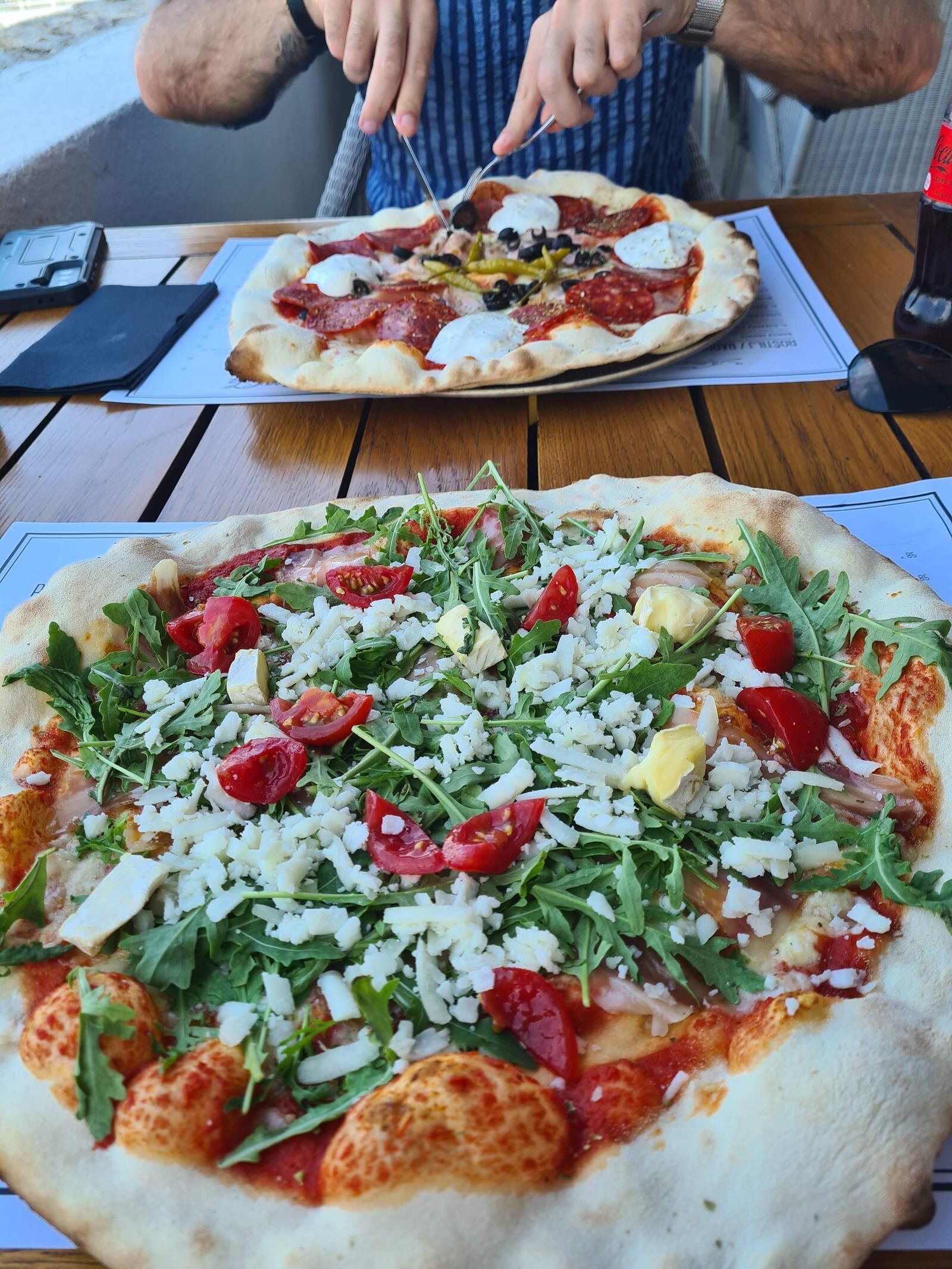 two large pizzas on a wooden table