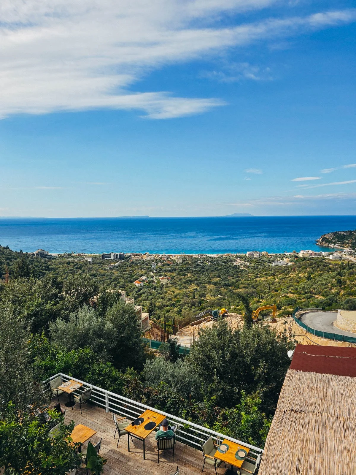 The coastal view of the Albanian Riviera  from a hotel balcony with blue water and green trees stretched out into the far distance