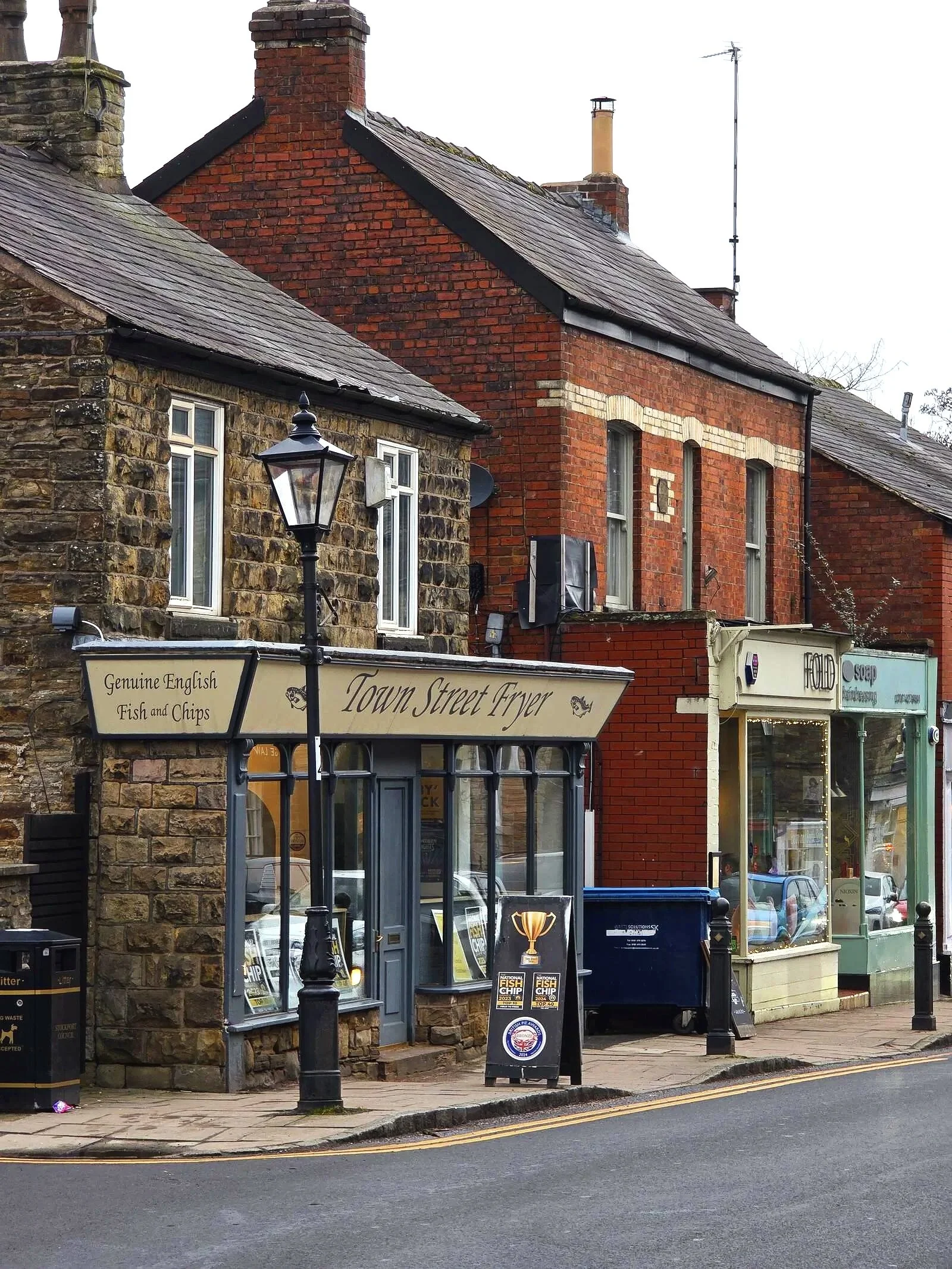 a charming street with traditional stone and shopfronts in Marple Bridge, High Peak