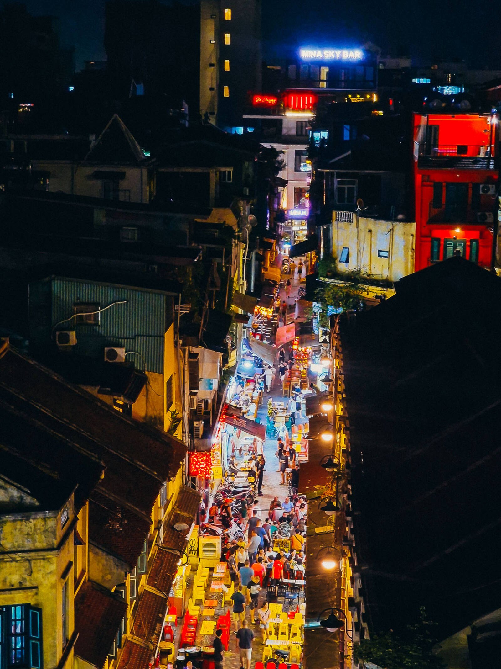 a busy lit up street at night in hanoi beer street