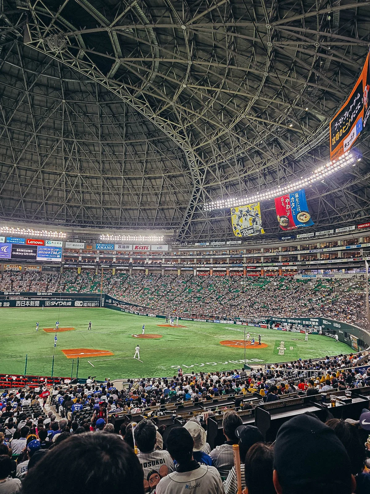 An indoor baseball arena with a full crowd