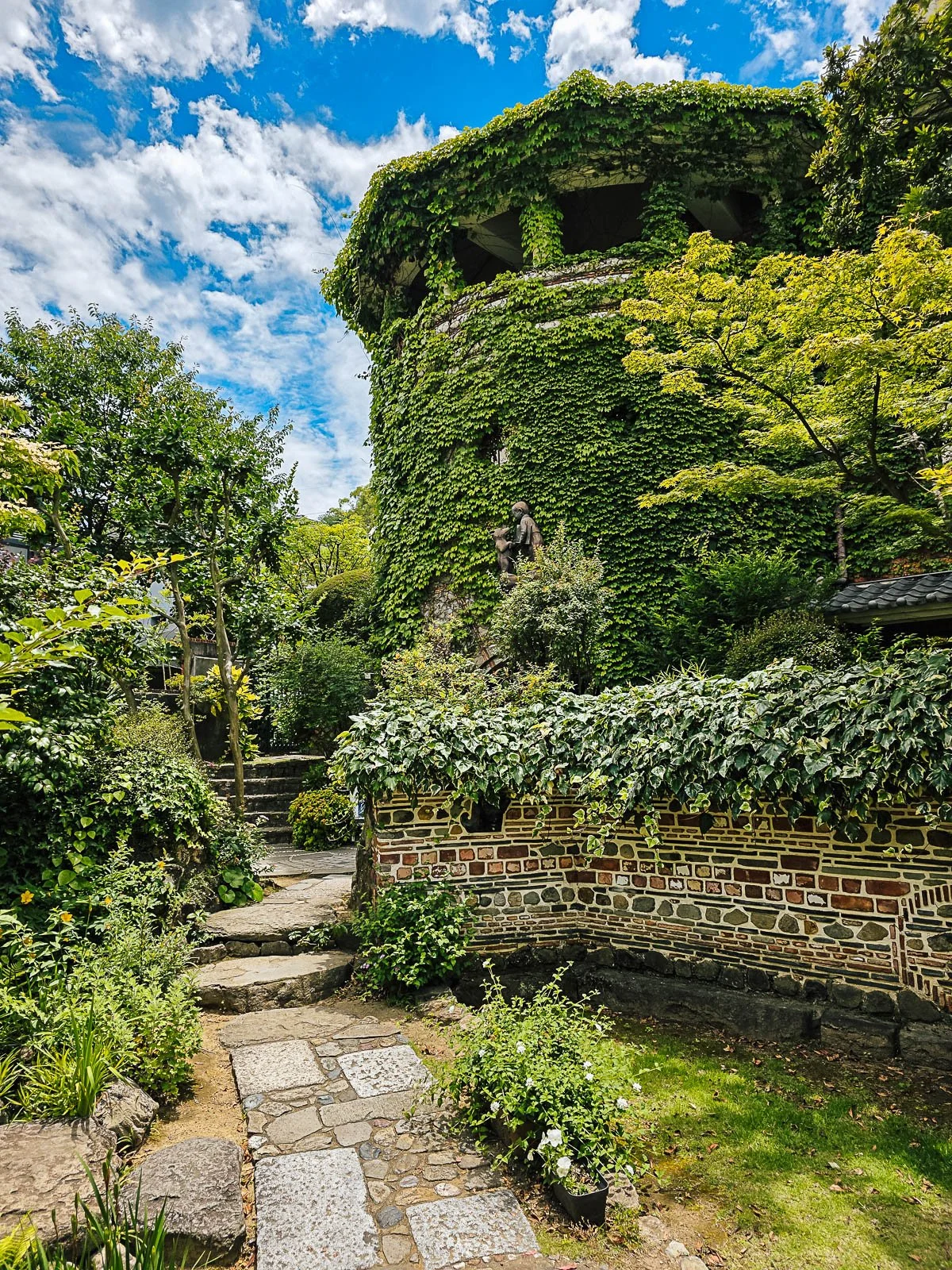 a house covered in vines and surrounded by a lush, full garden