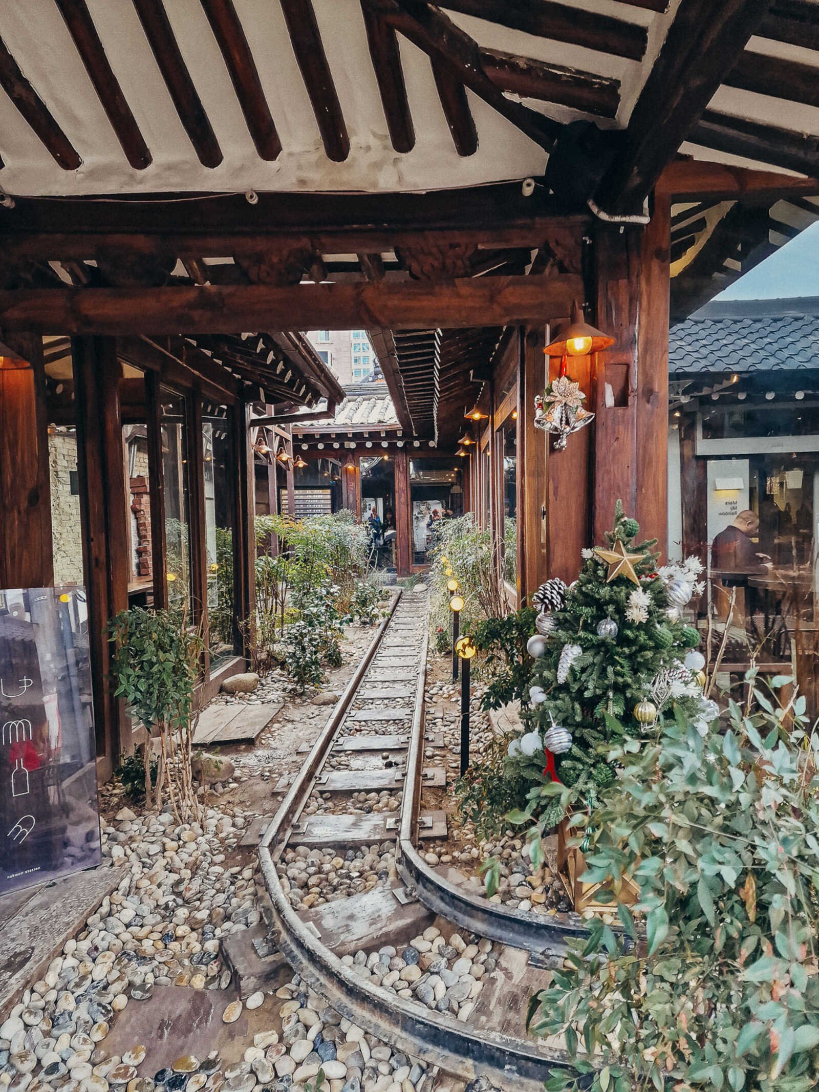 a cafe in a traditional wooden building in South Korea with a train track running through it