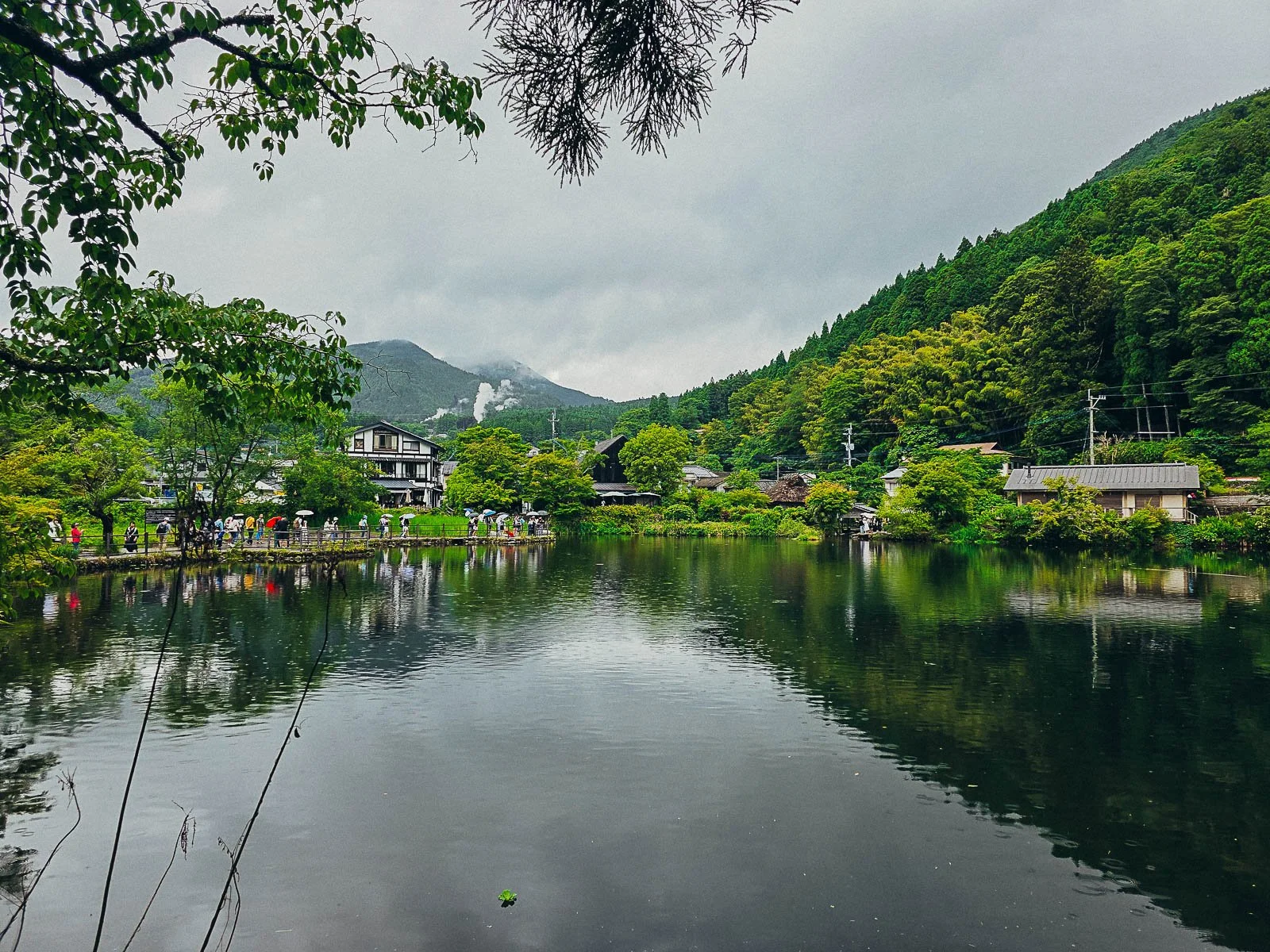 A lake surrounded by buildings and lush hills