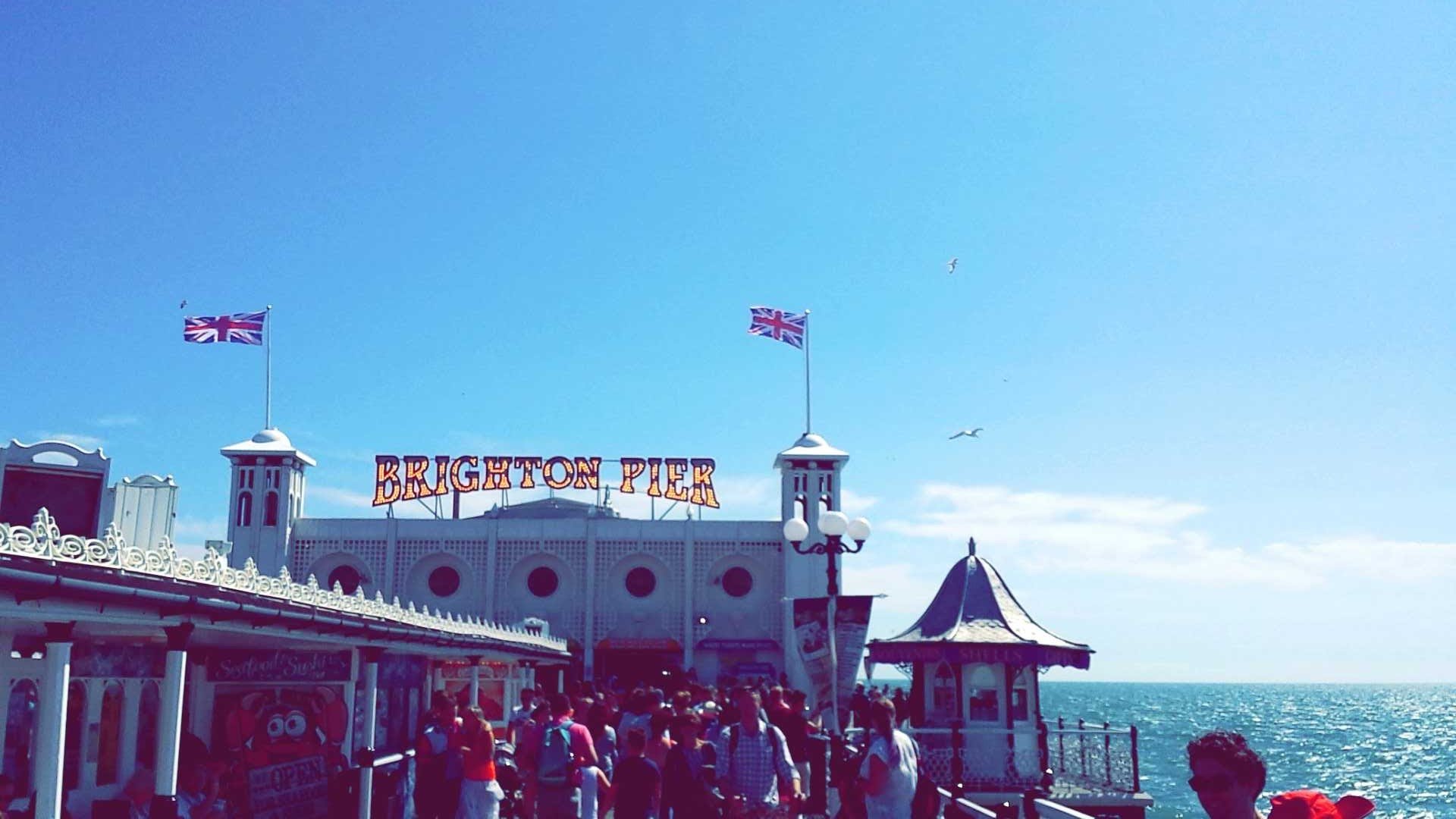 front on brighton pier on a sunny day with flags flying