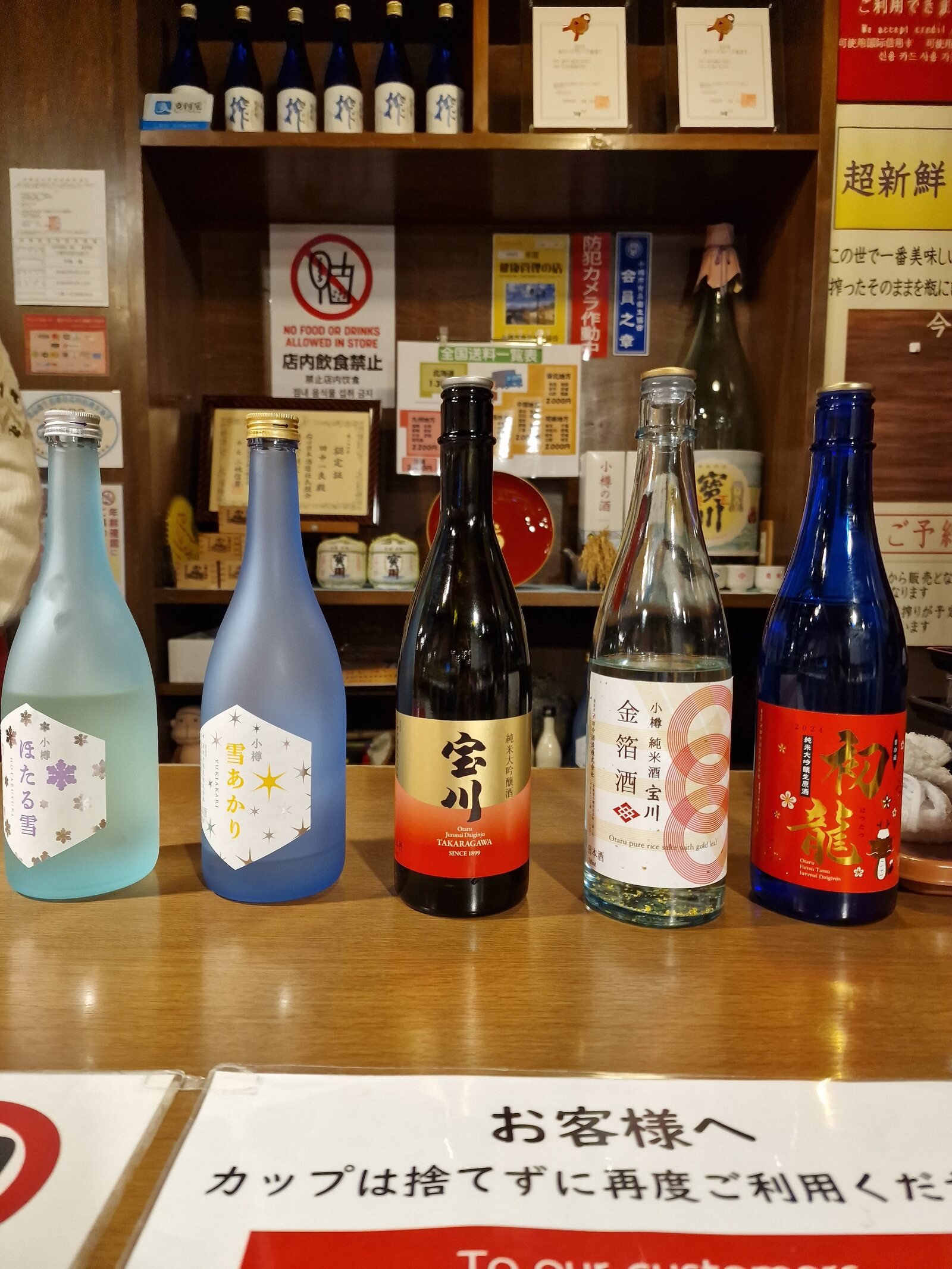 5 different sake bottles lined up on a table